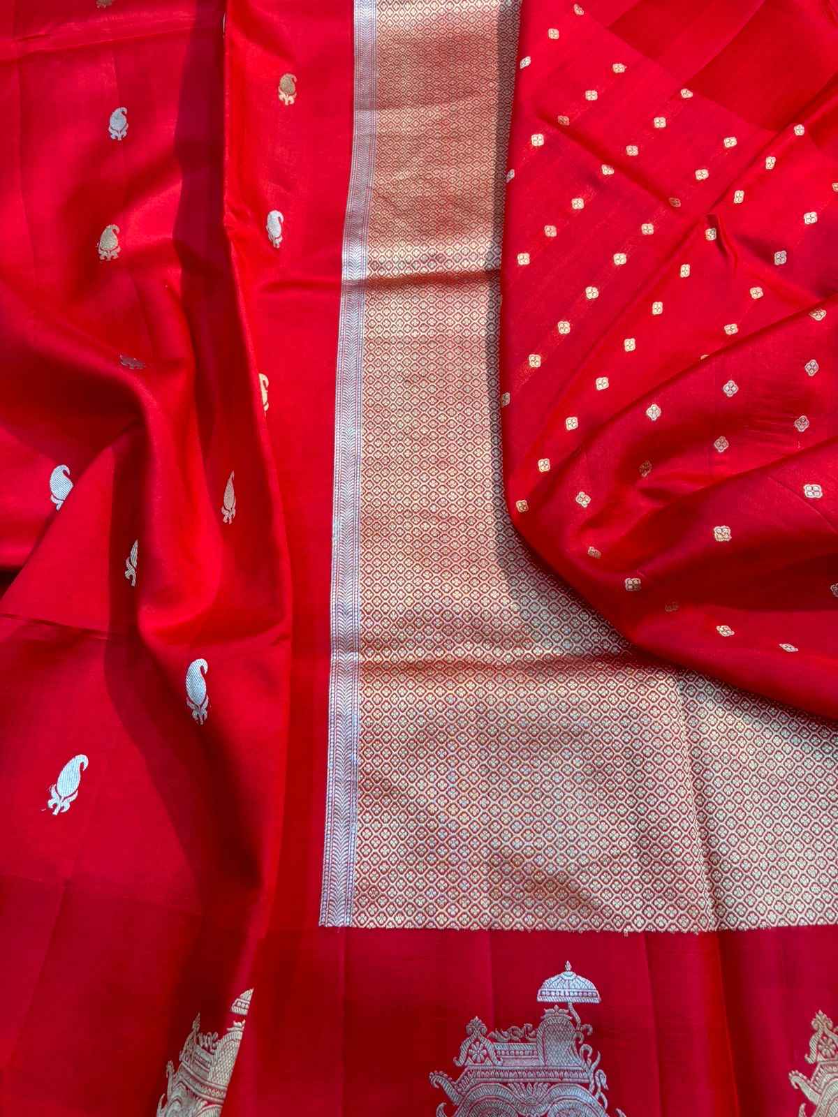 Red saree with silver-tone border panel and small scattered motifs, detailed close-up