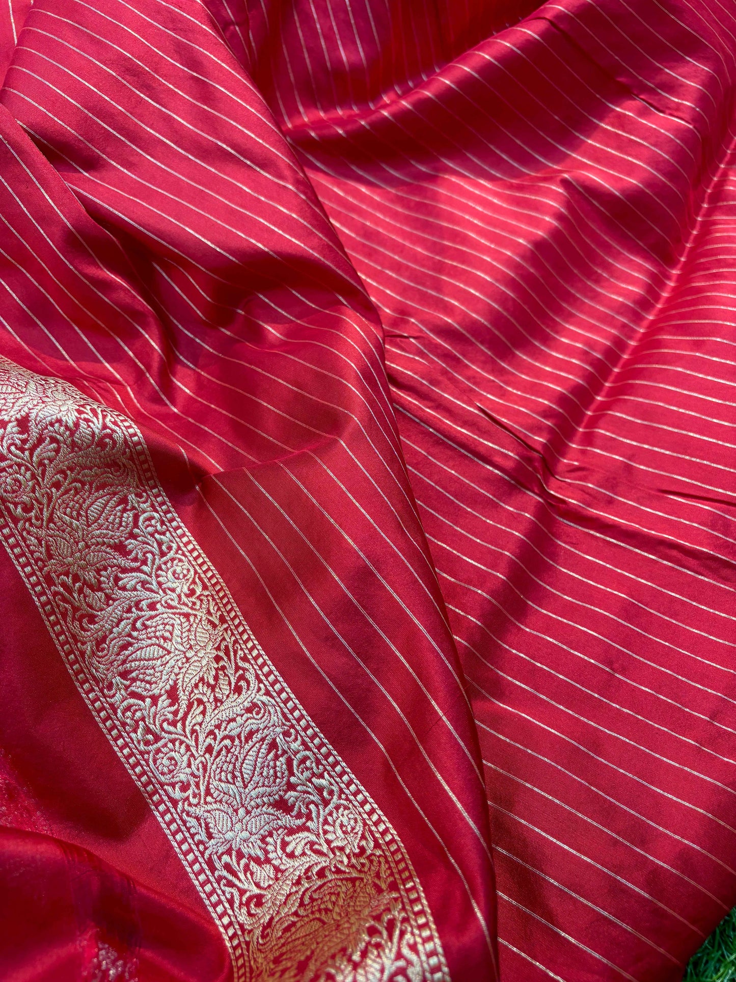 Banarasi handloom saree with deep red fabric, fine stripes, and ornate silver border