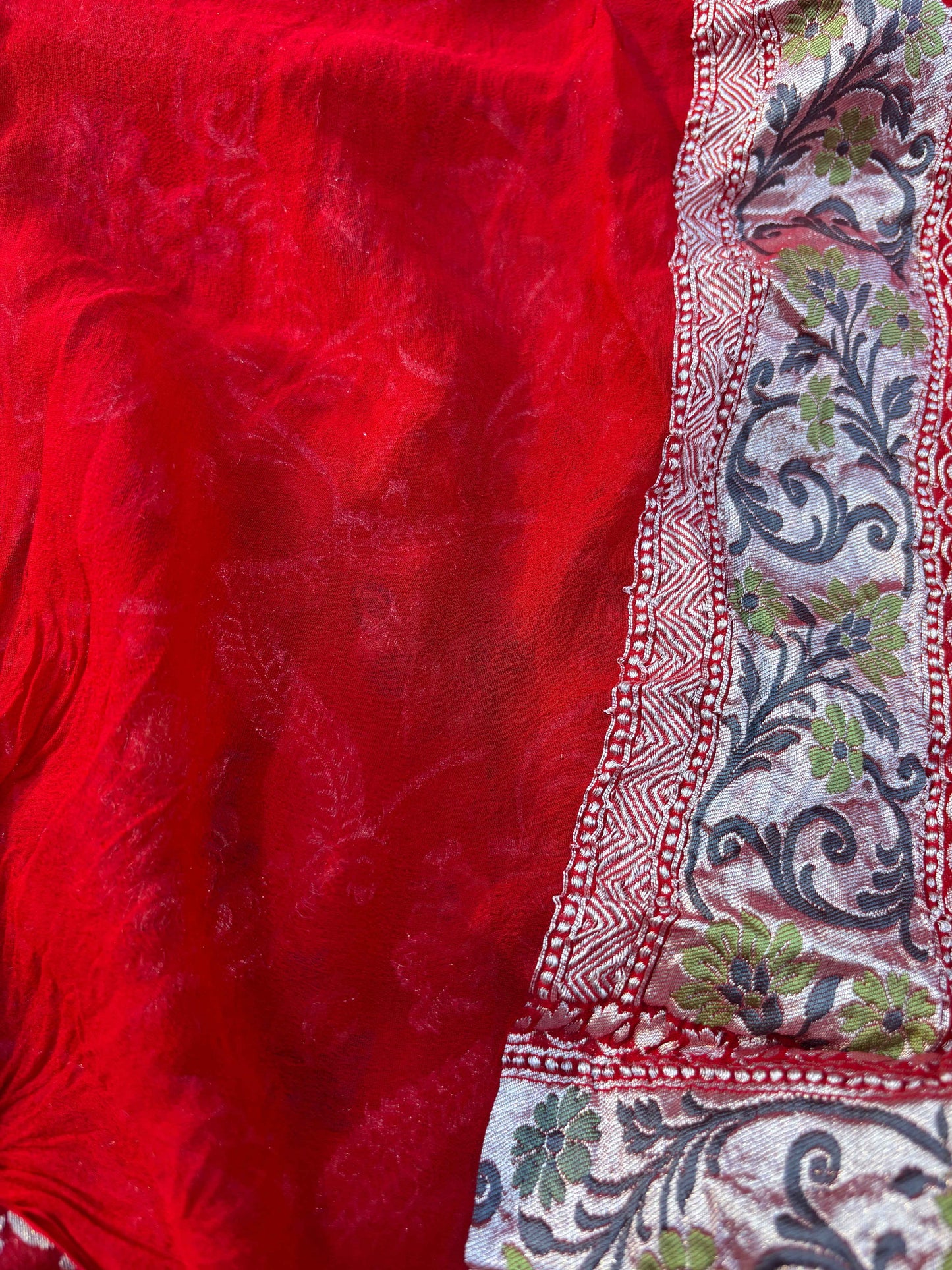 Red sari with textured body and multicolor floral border edging