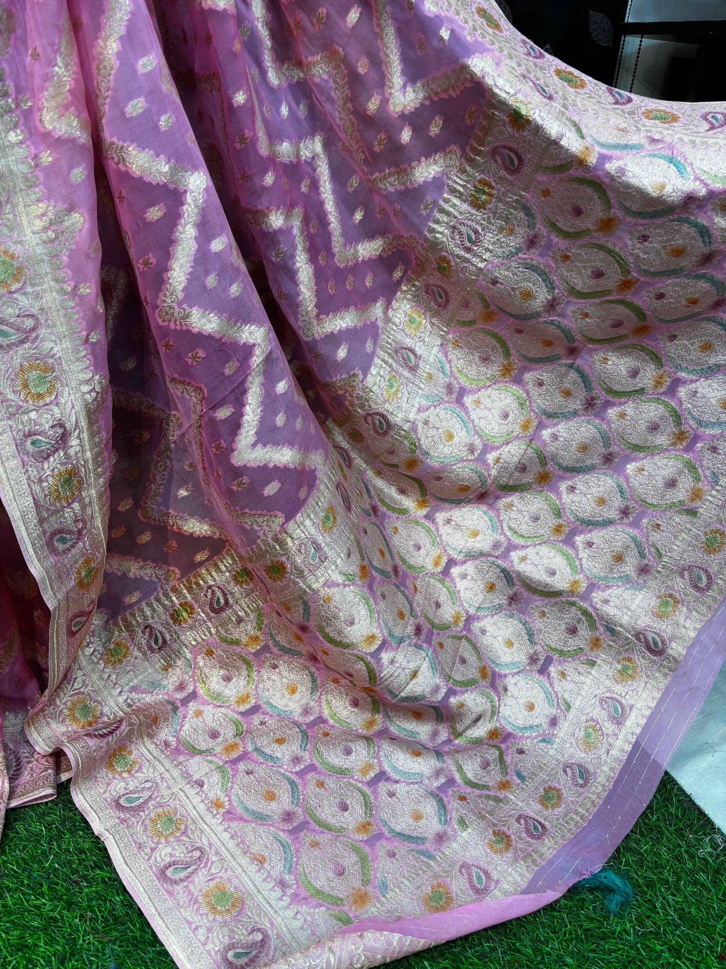 Saree border close-up: cream ground with gold accents and pastel floral motifs