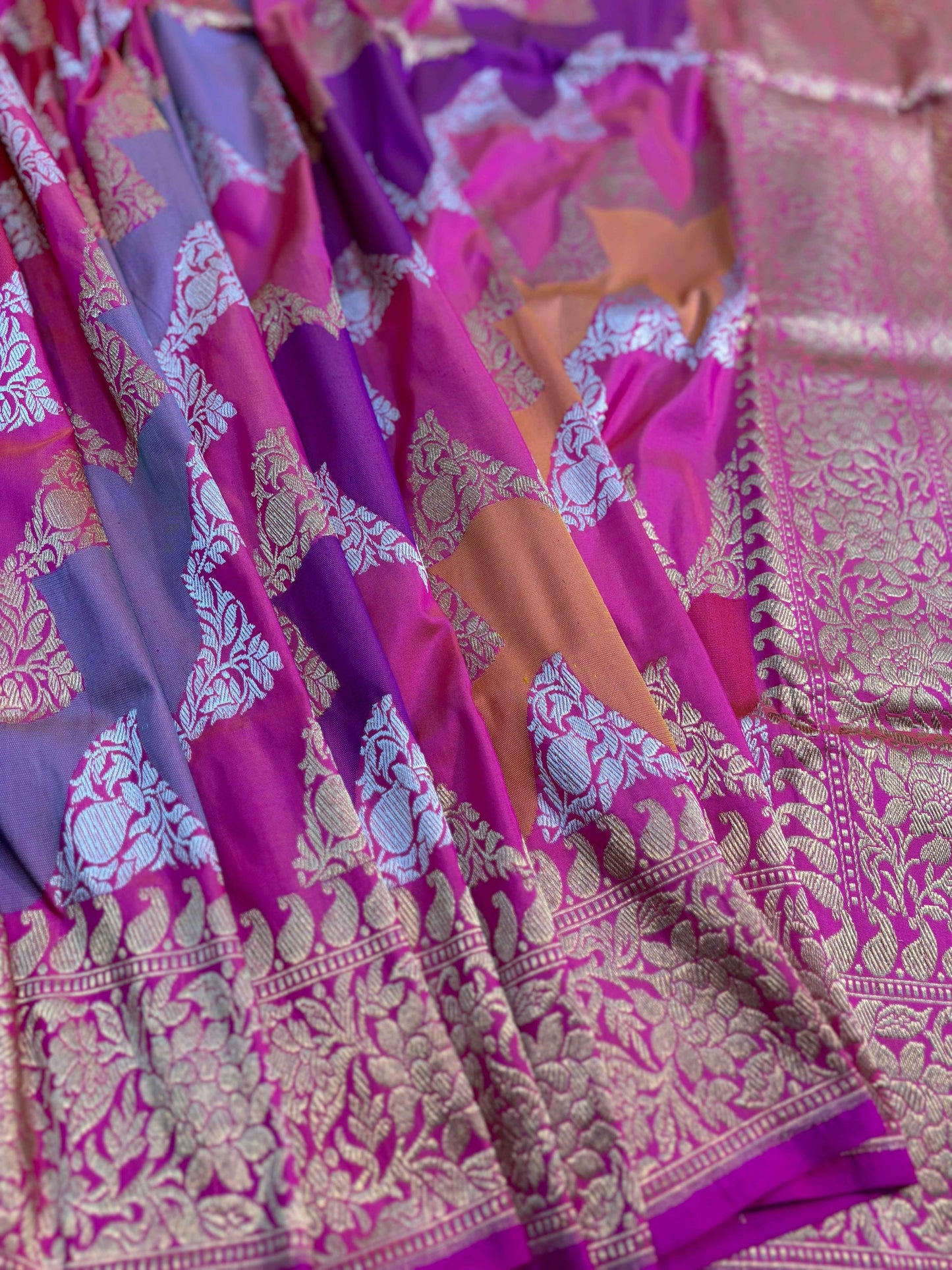 Purple handloom saree with pink pallu, floral motifs, and wide gold zari border