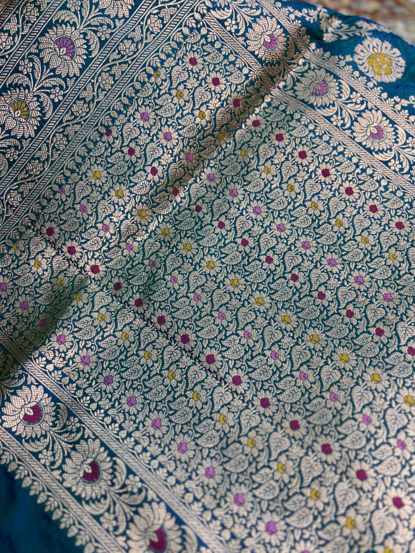 Blue saree with dense floral spray and ornate corner border, close detail