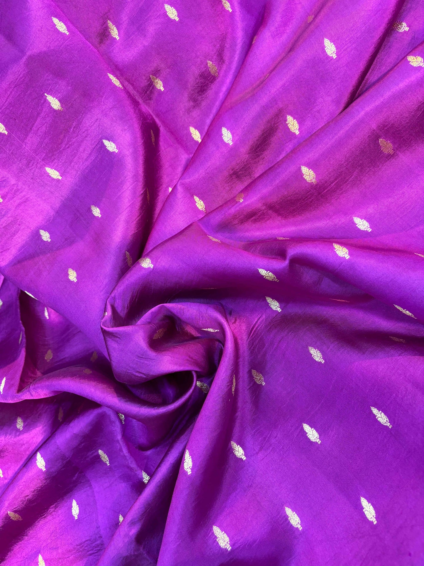 Dark purple silk saree fabric with small golden leaf motifs and fine sheen
