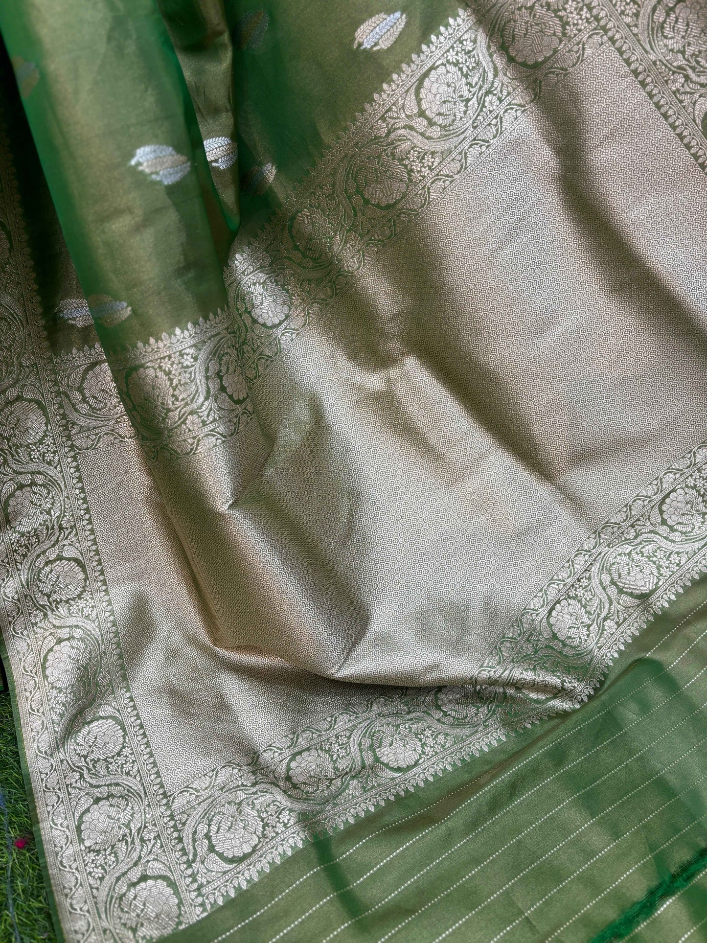 Light green and off-white Banarasi saree fabric with woven paisley motifs and zari border