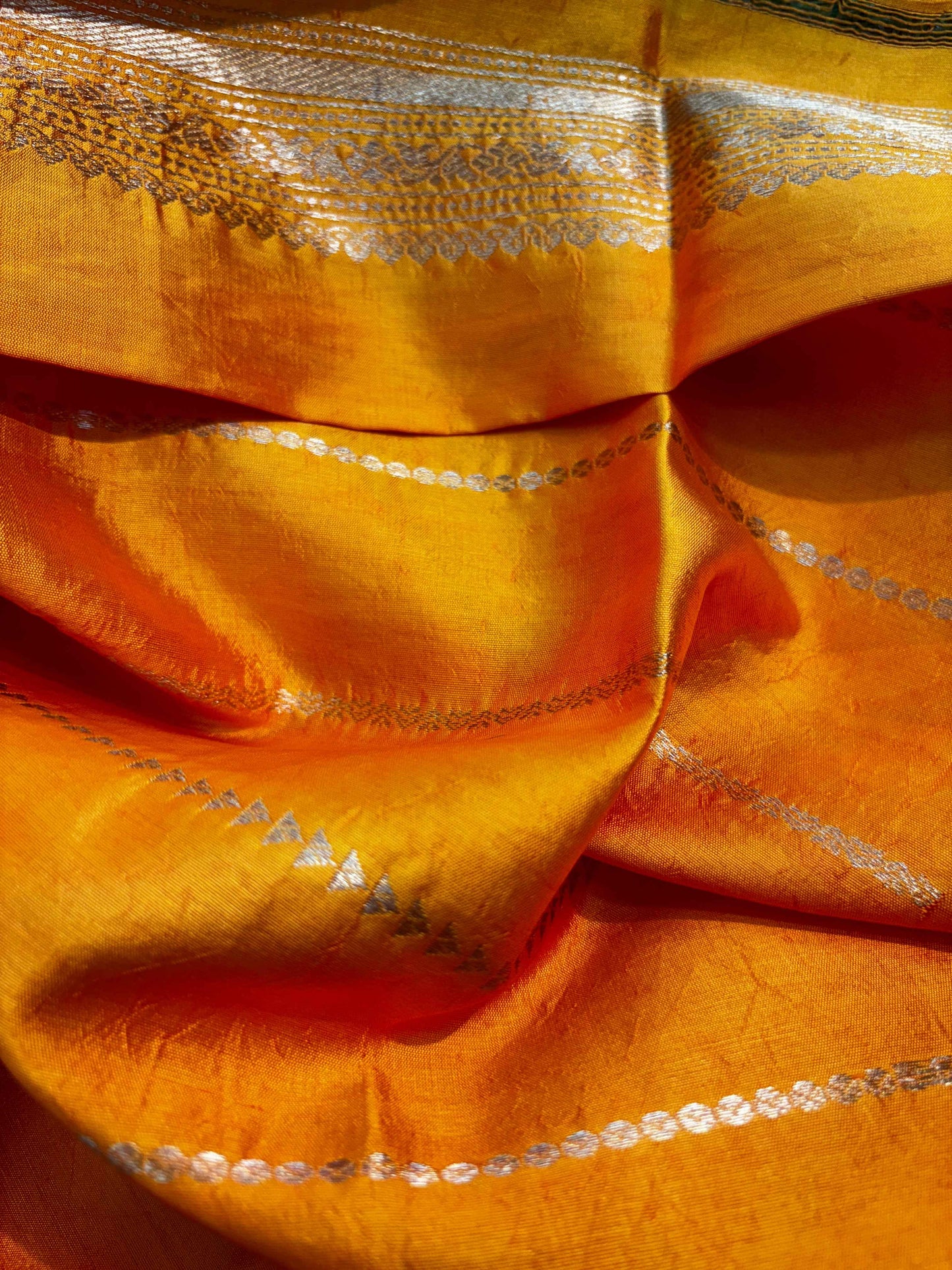 Yellow Banarasi saree close-up with metallic border and floral striping