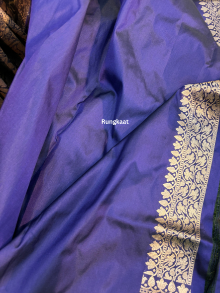 Purple silk saree fabric close-up with gold brocade border and textured sheen
