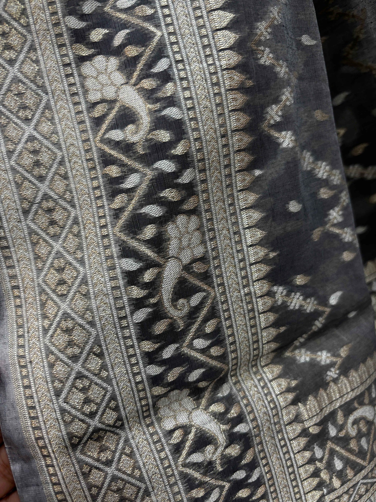 Gray saree detail with silver woven stripes and leaf-like motifs