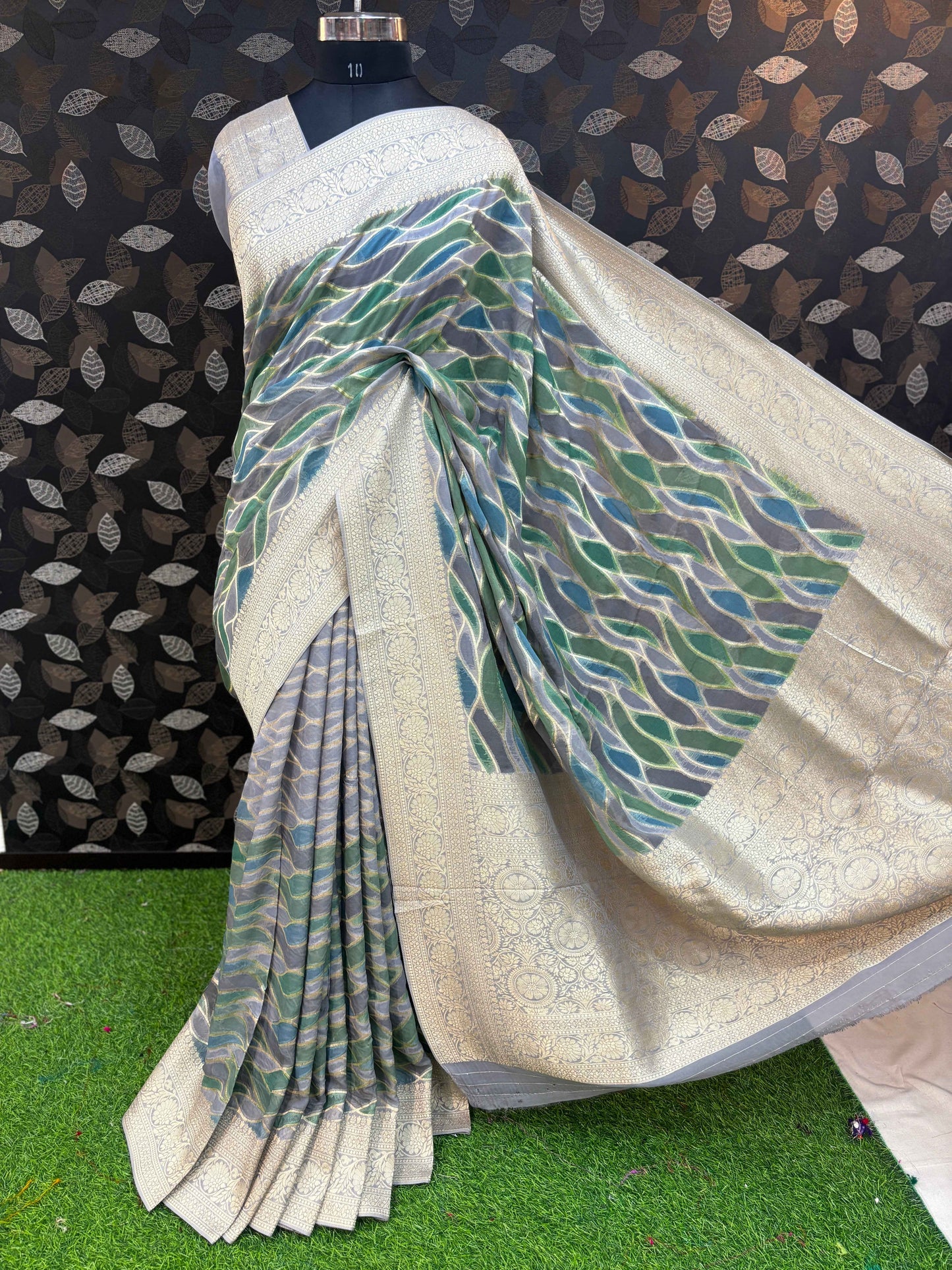 Bluish gray georgette saree with teal-blue wave pattern and ornate cream-gold pallu border