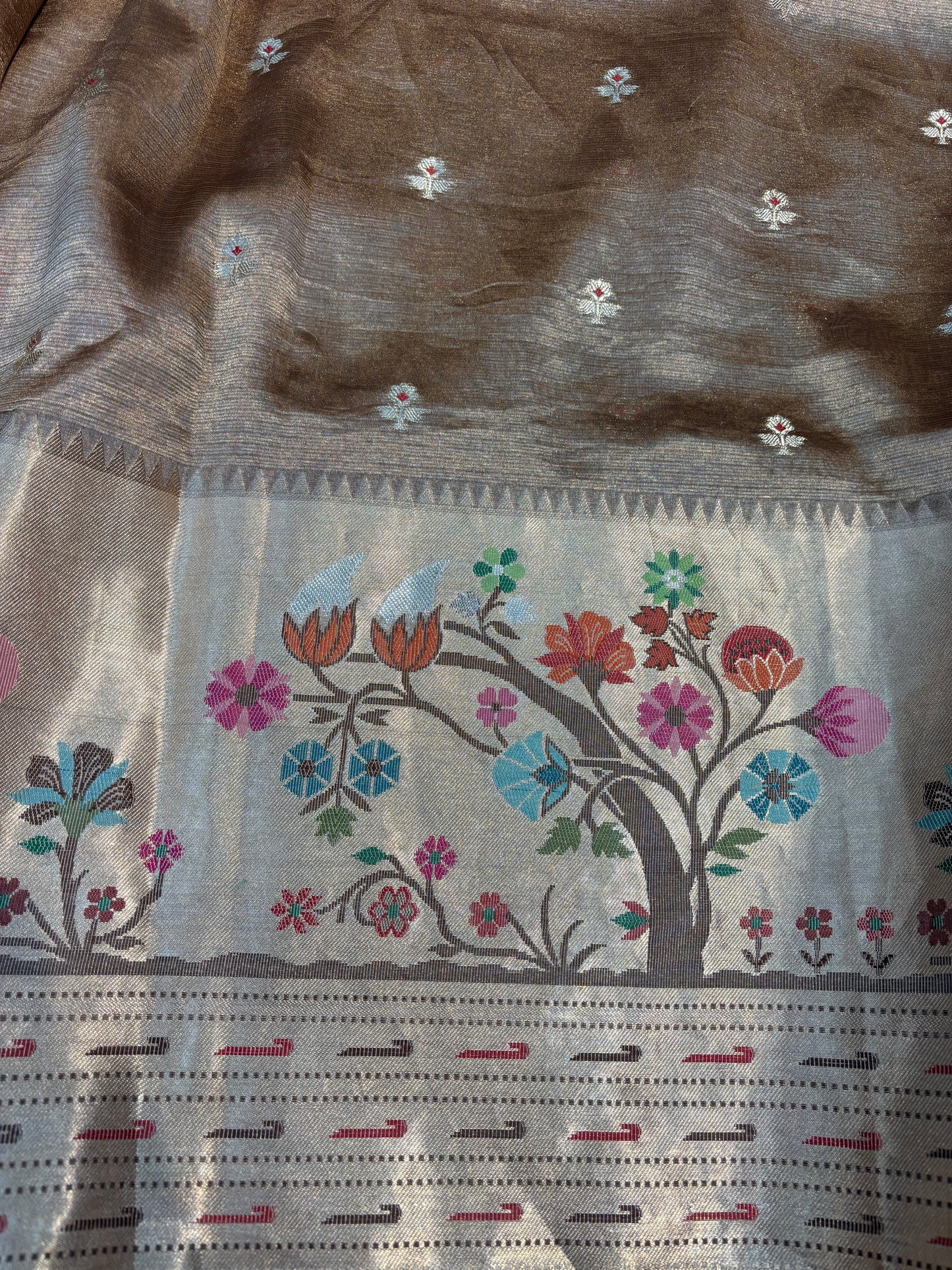 Beige saree with brown pallu, small floral sprigs and multicolor floral border
