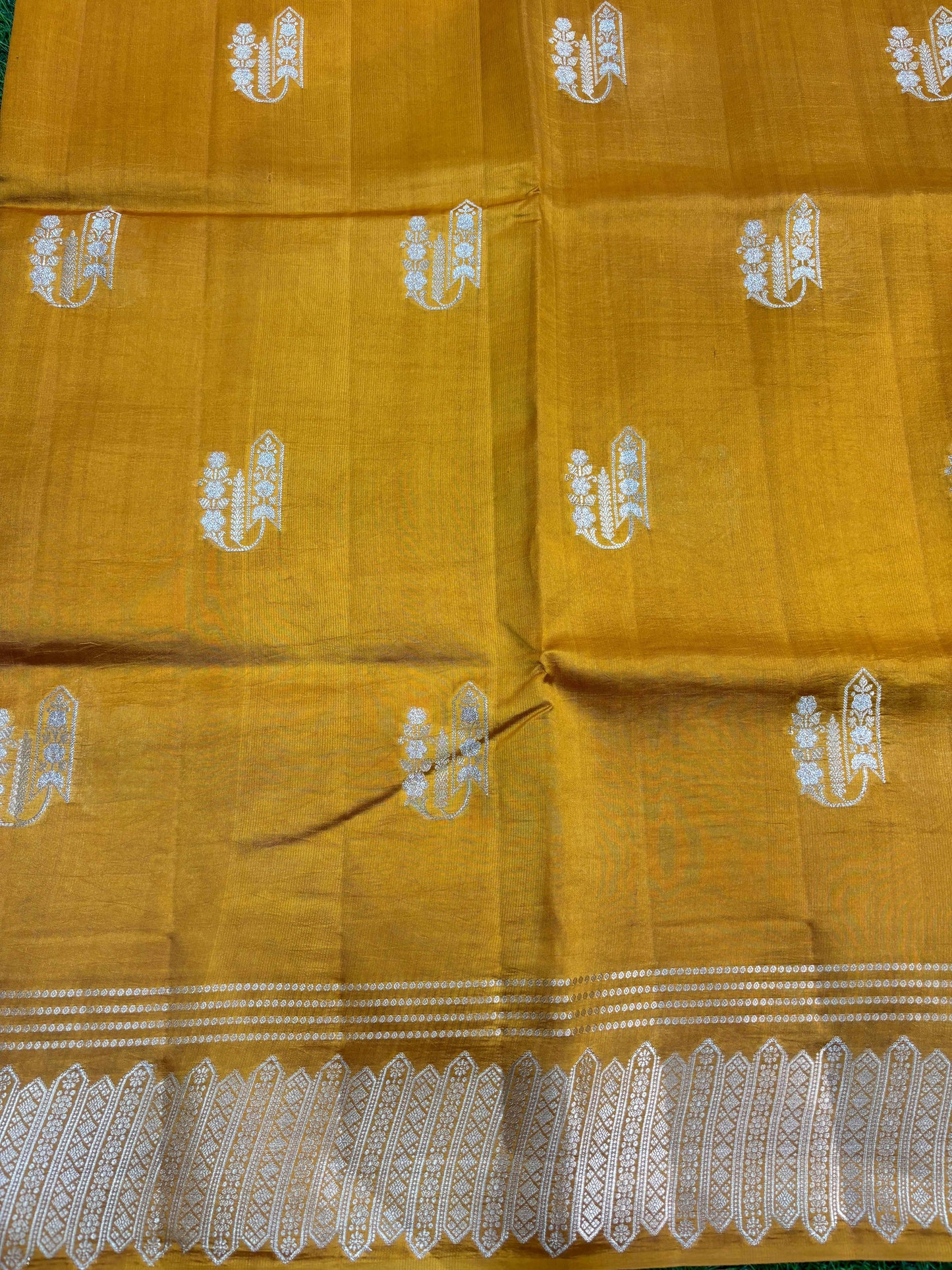 Mustard yellow saree with allover small silver motif pattern and wide zari border