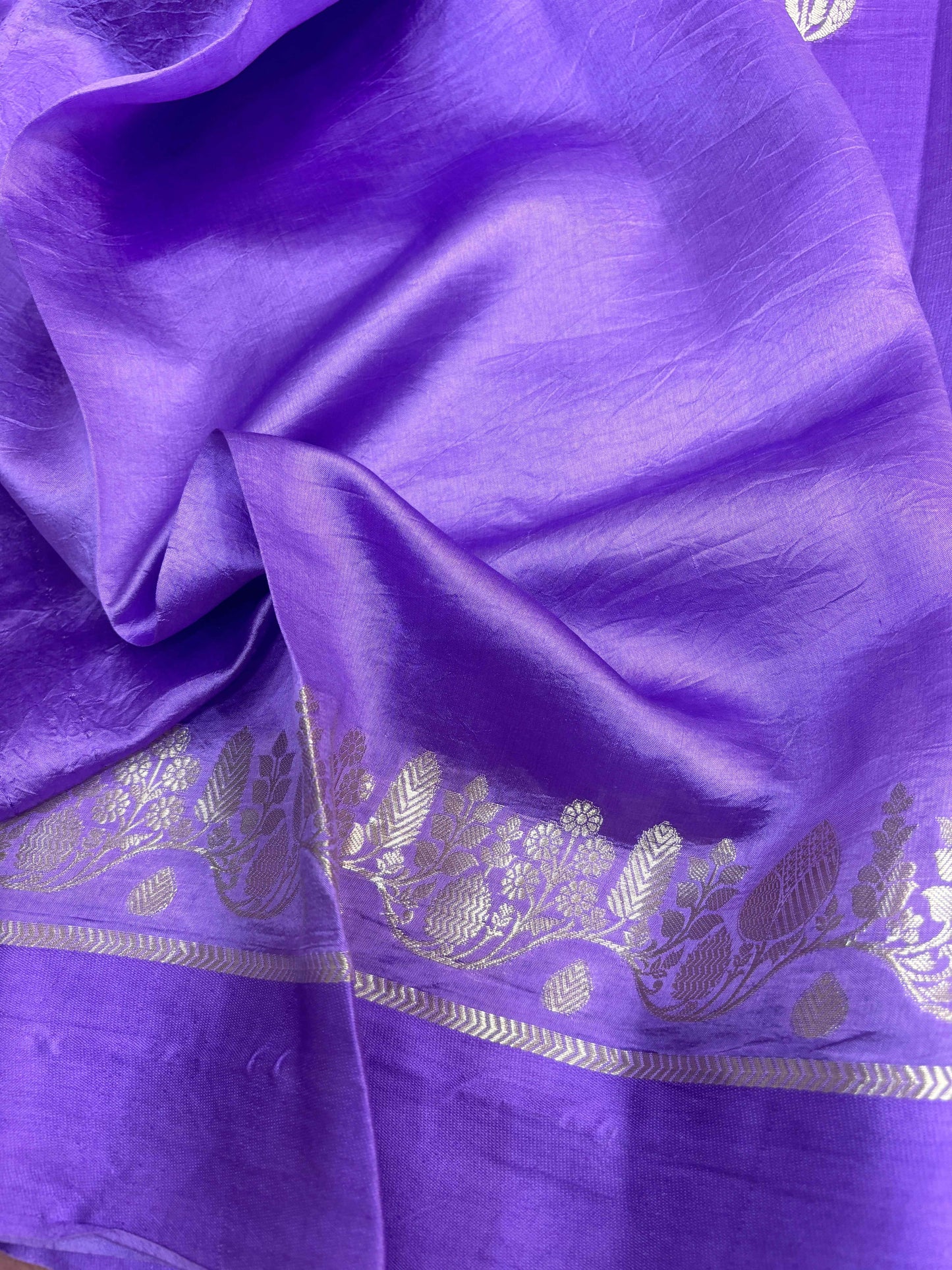 Lavender saree draped with gold leaf motif band along the hem
