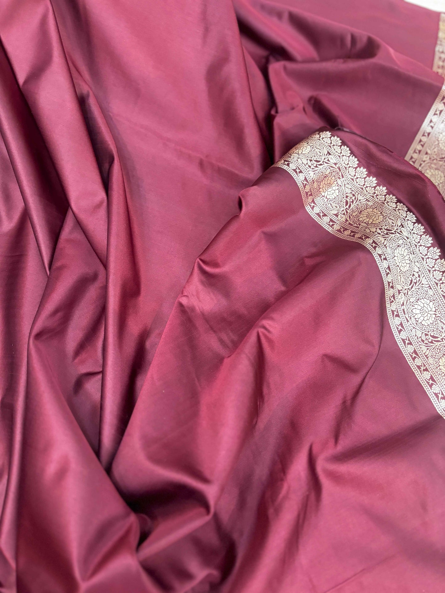 Rose-magenta saree with wide silver-toned border and woven medallion panel