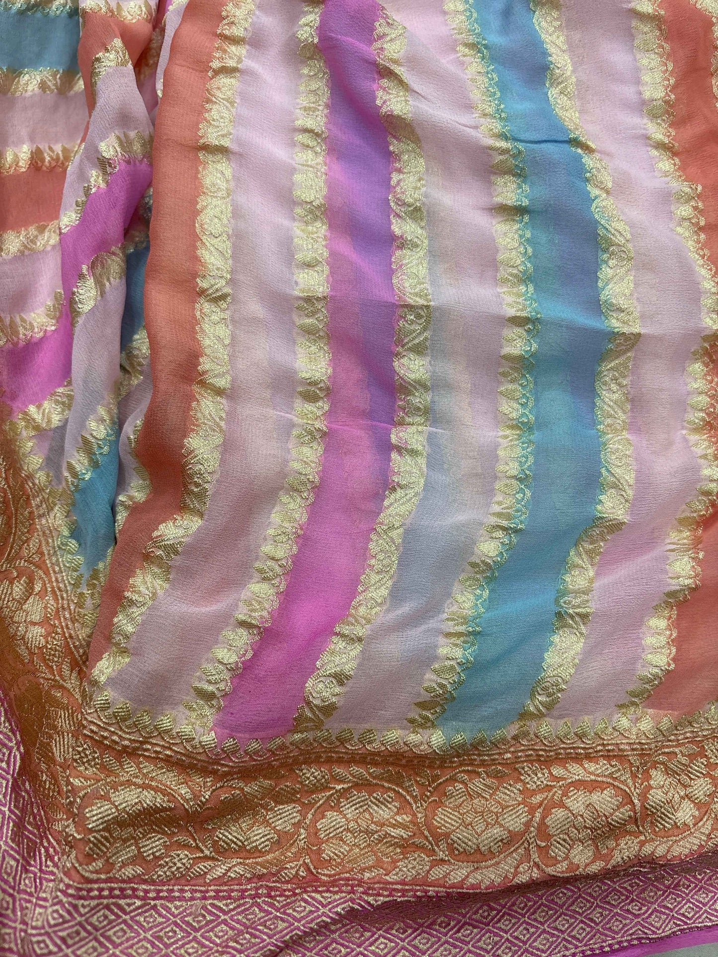 Pink and purple georgette saree with gold striped pattern and ornate border
