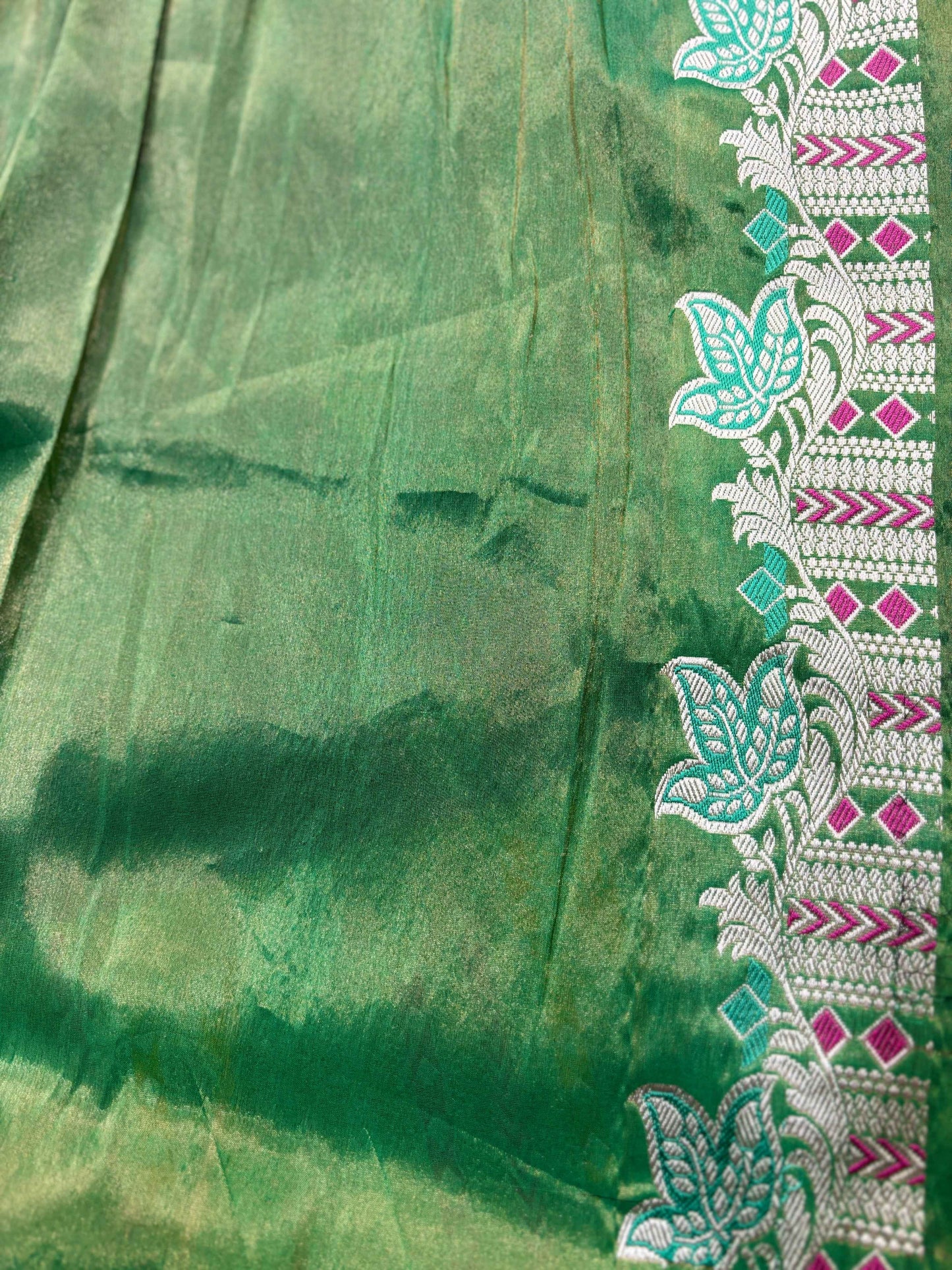 Green tissue saree with right-side floral vine border and geometric stripe trim