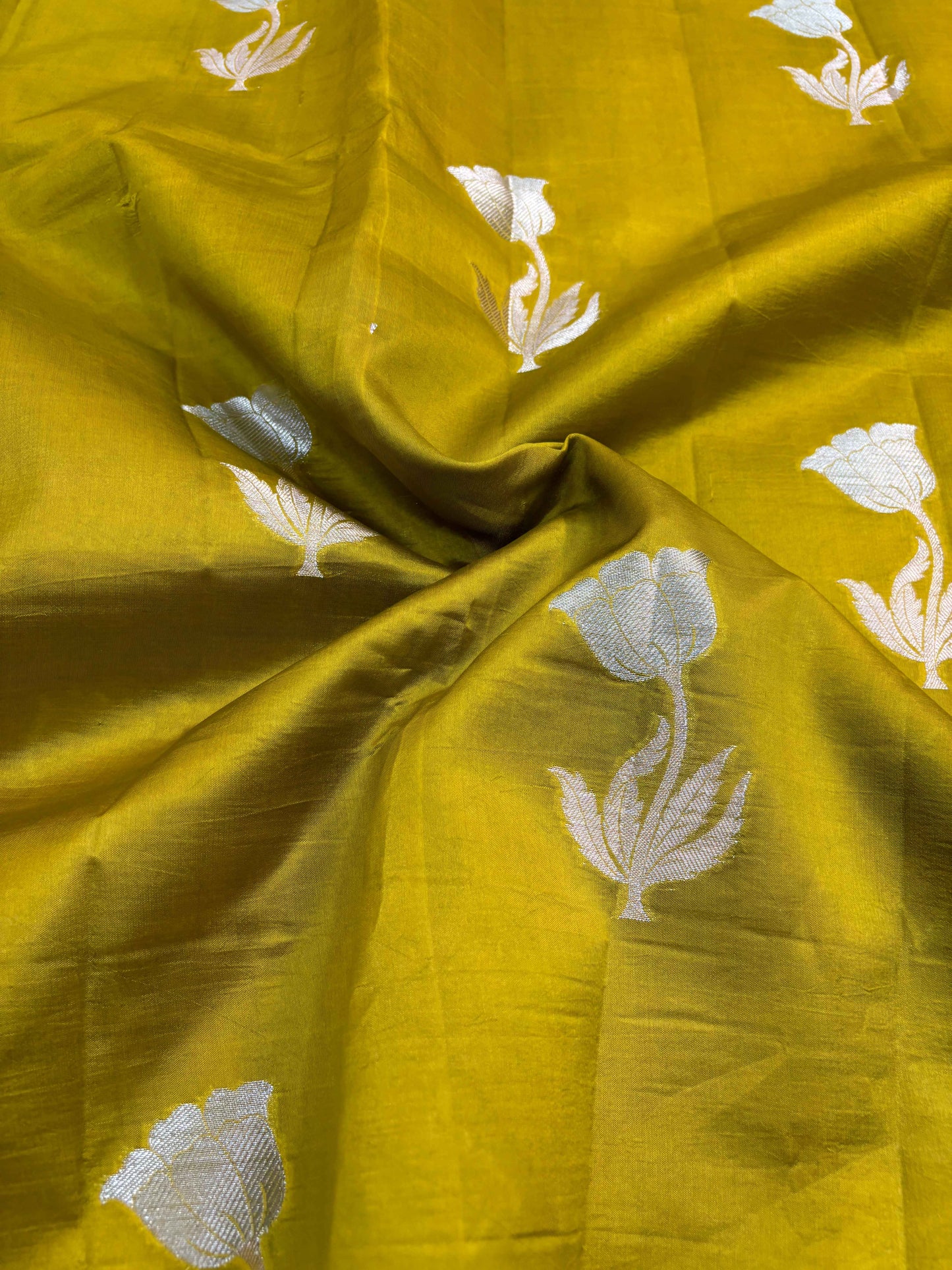 Mustard yellow draped saree with white floral motifs across the fabric
