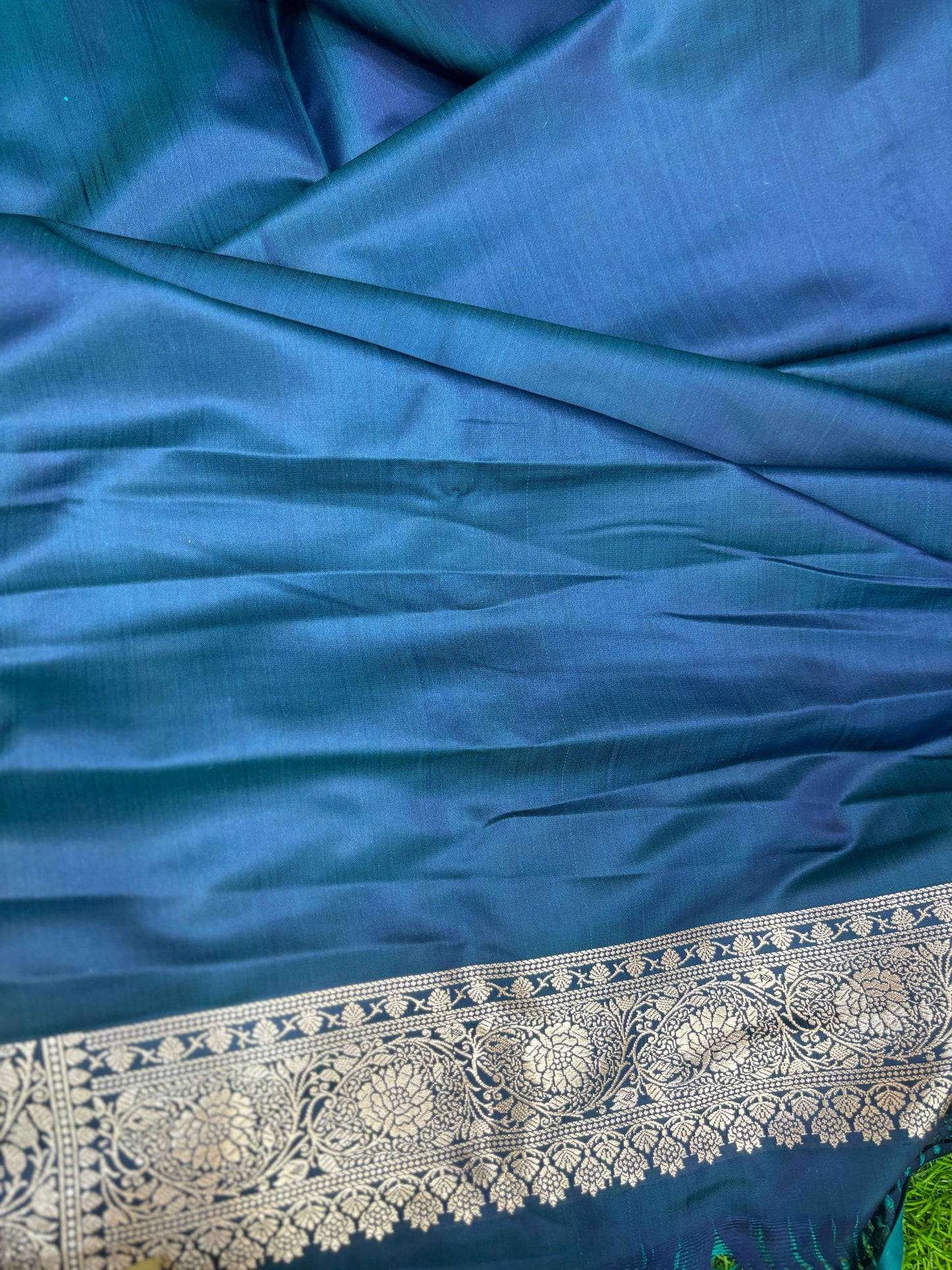 Blue Banarasi saree fabric close-up with silver zari border stripe