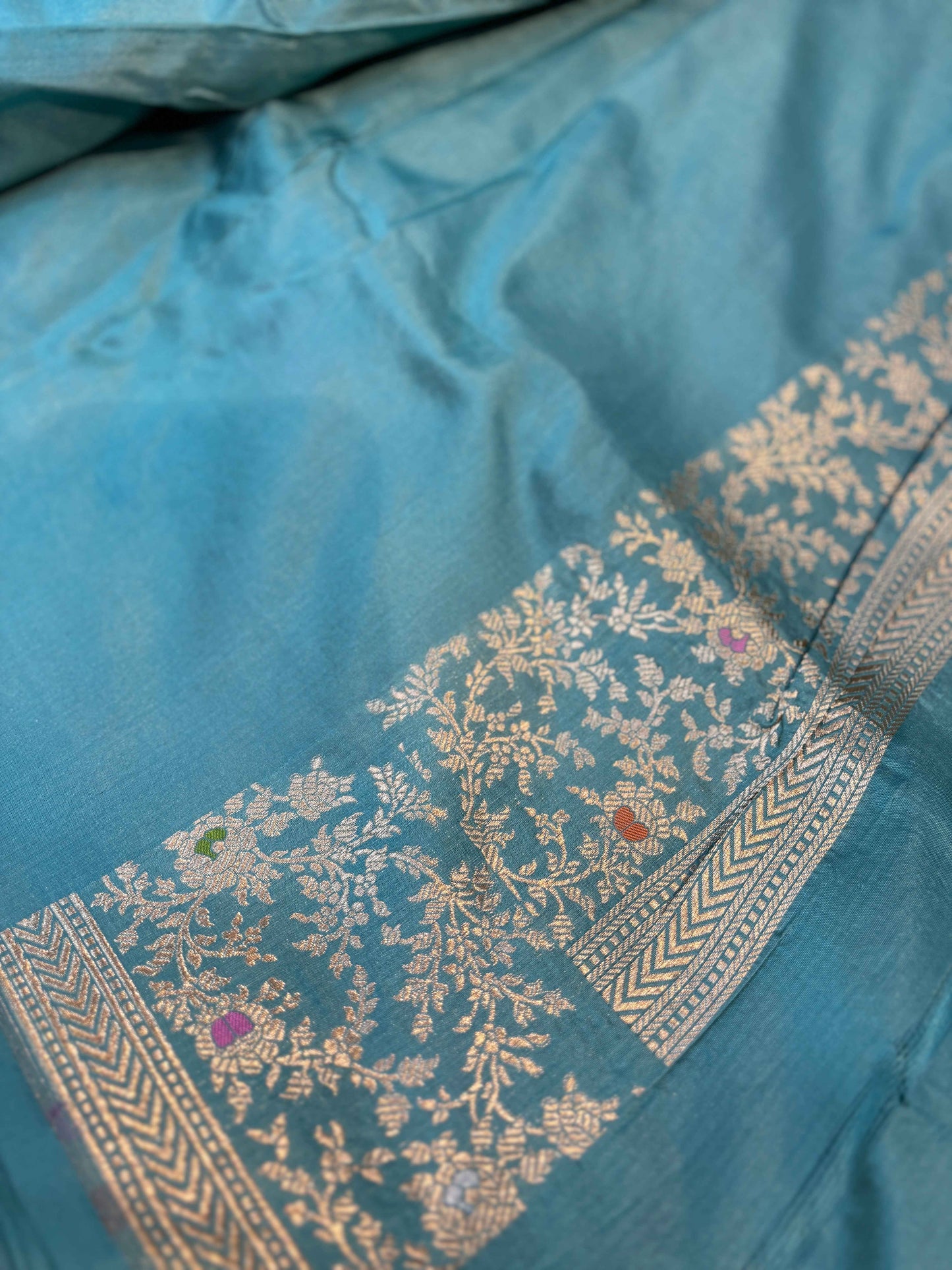 Sky blue saree with gold floral panel and narrow woven border