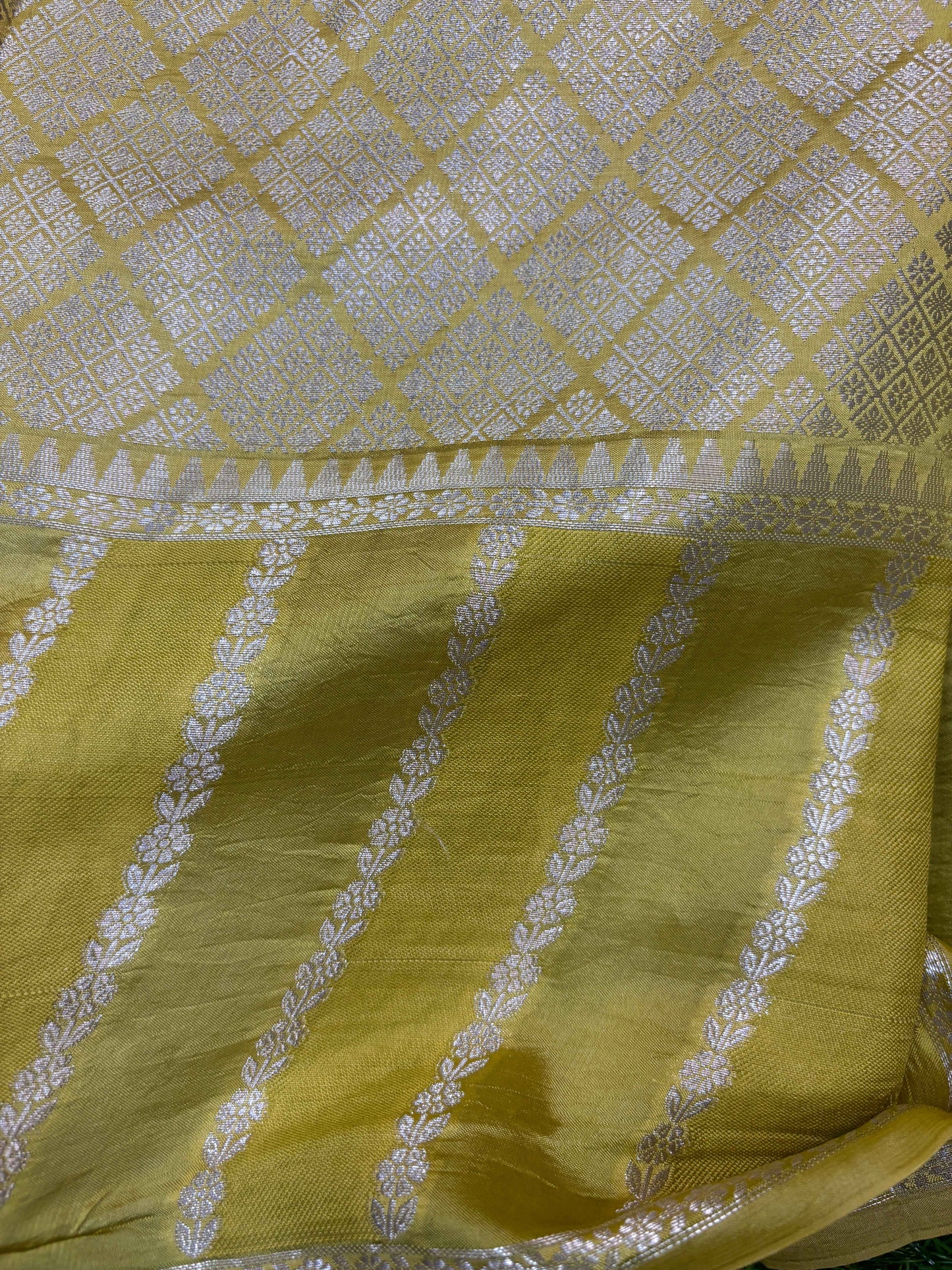 Yellow saree with pale silver lattice upper panel and woven stripe border