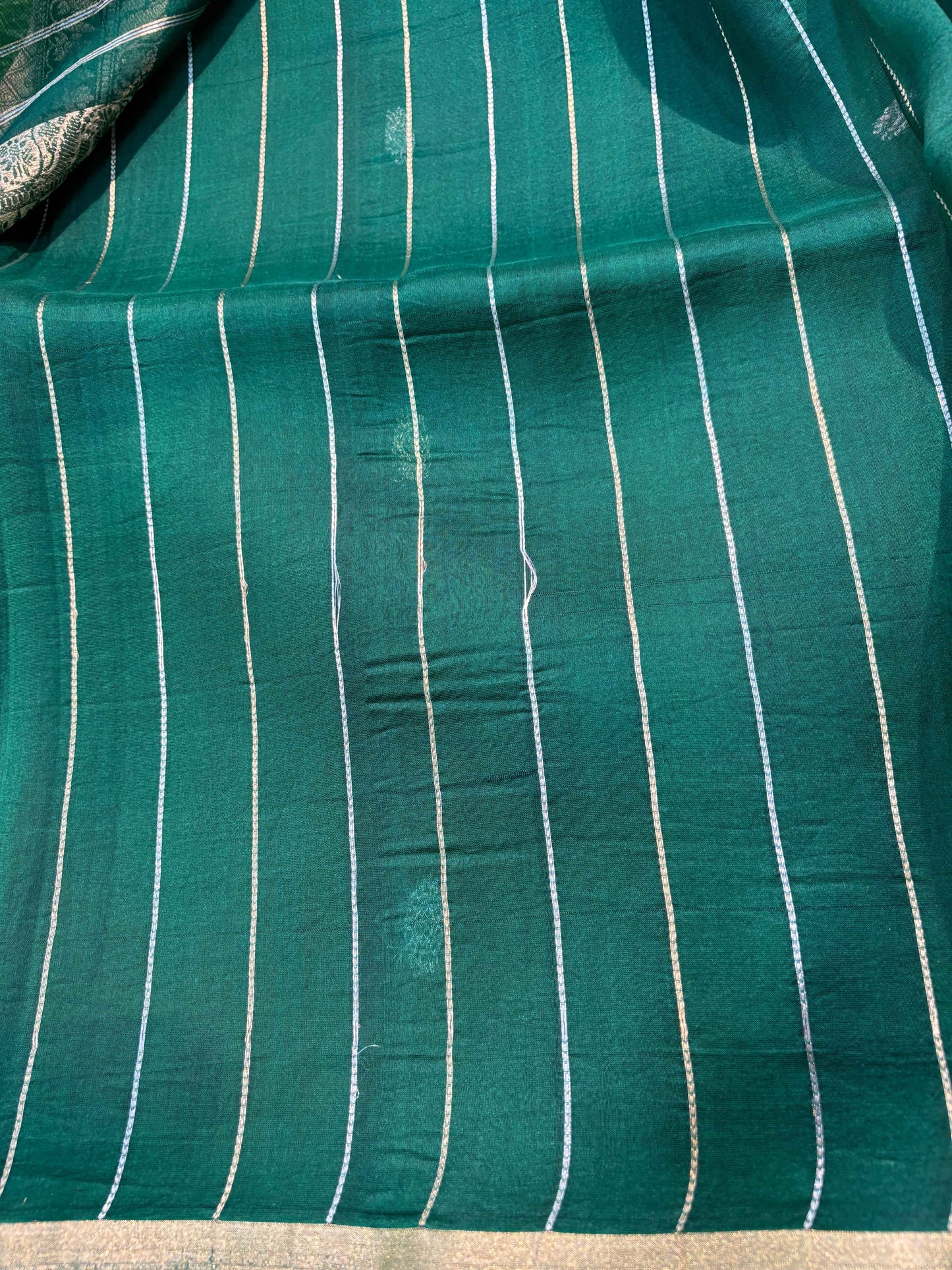 Green silk saree with thin gold vertical stripes on the body