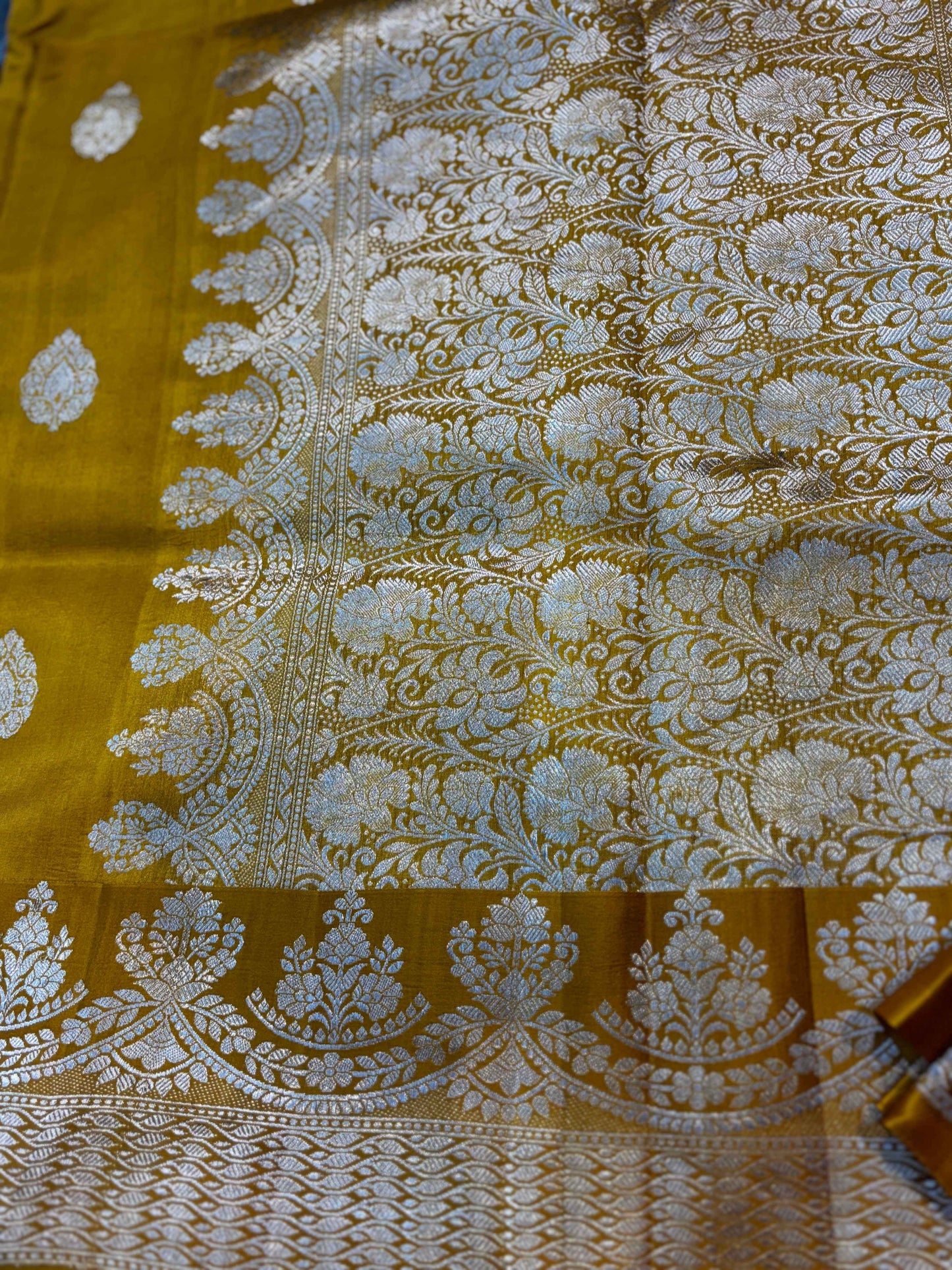 Mustard yellow saree with silver zari floral panel and ornate border