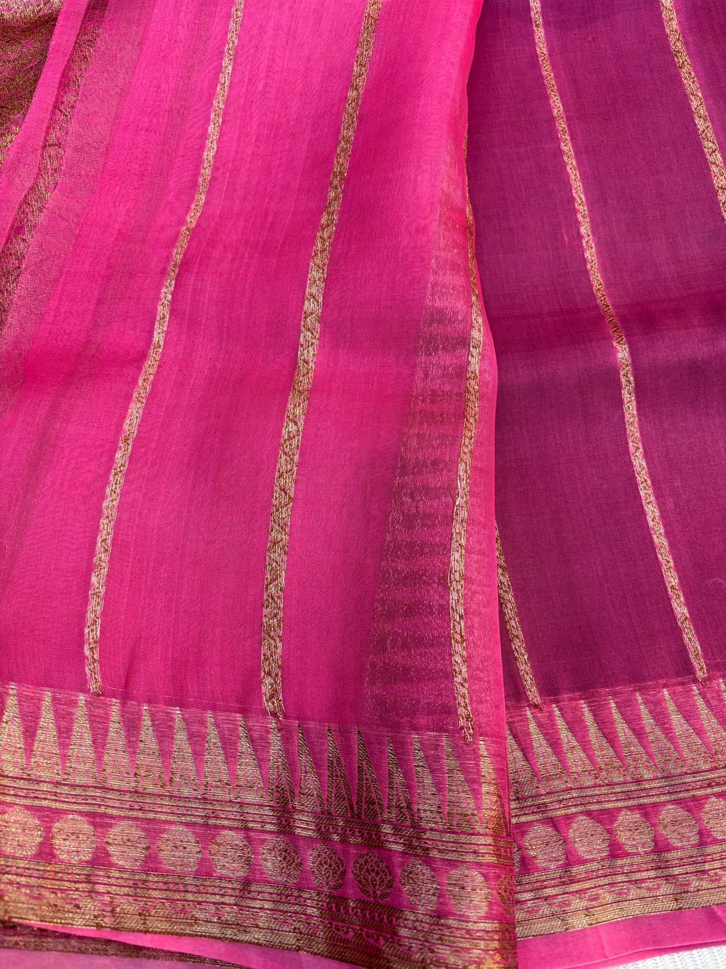 Pink silk saree with gold zari stripes and woven border