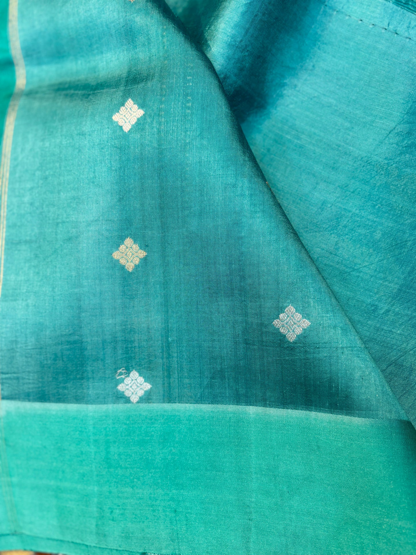 Dark sky blue handloom saree with small gold diamond motifs and teal border