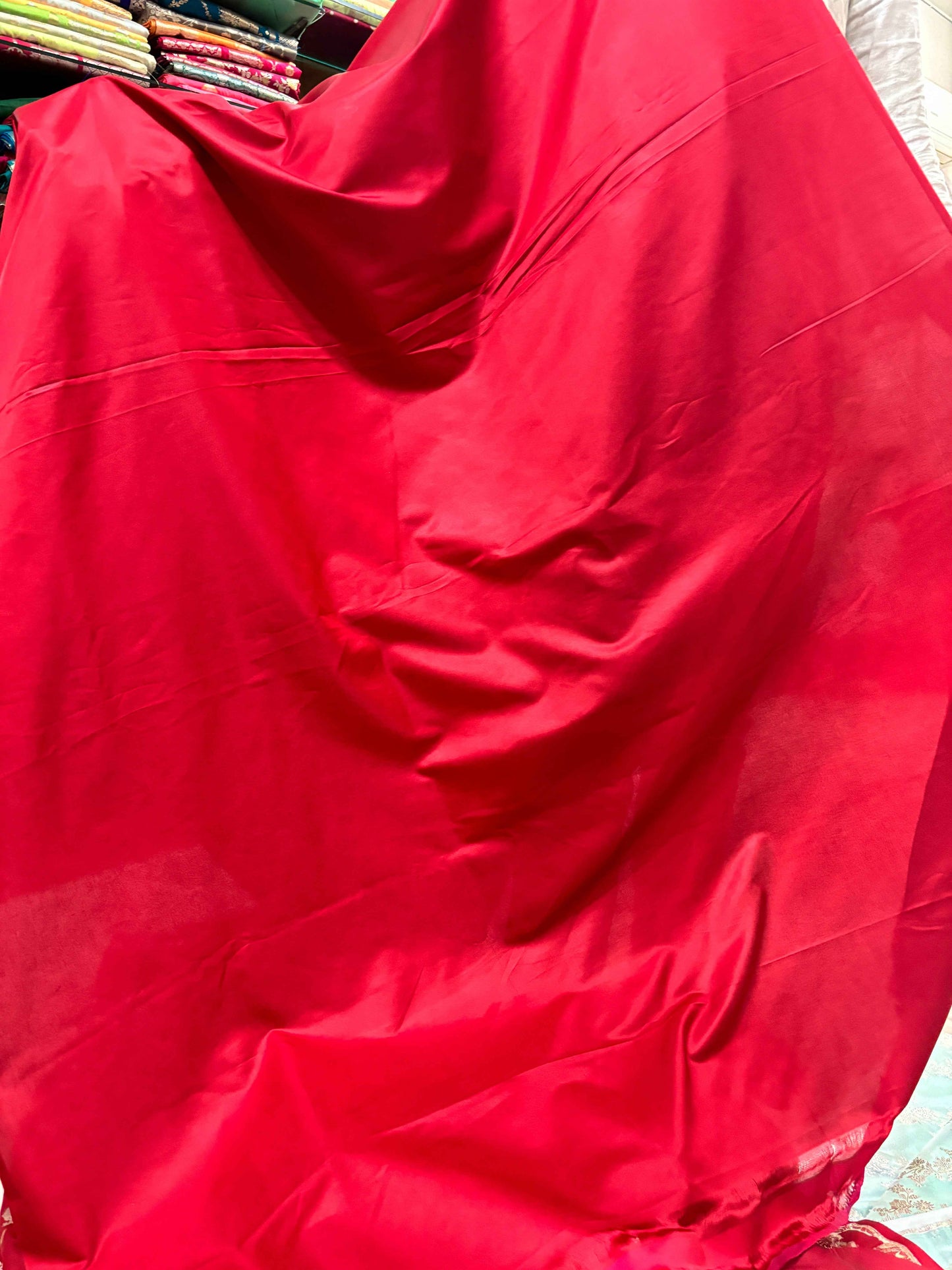 Red katan dress fabric with smooth sheen and folds