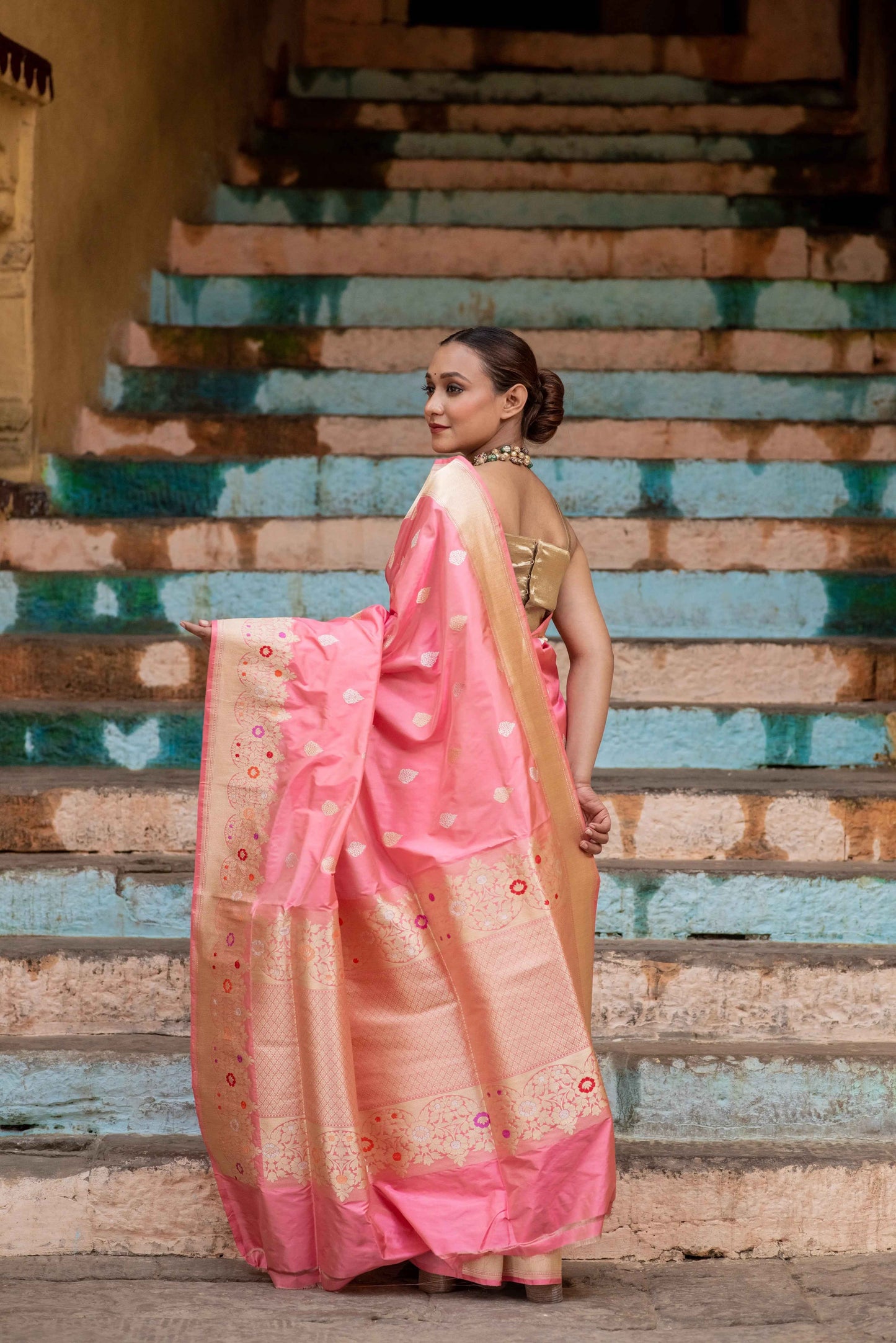 Pink katan saree with meena motifs and gold-toned border, side view drape