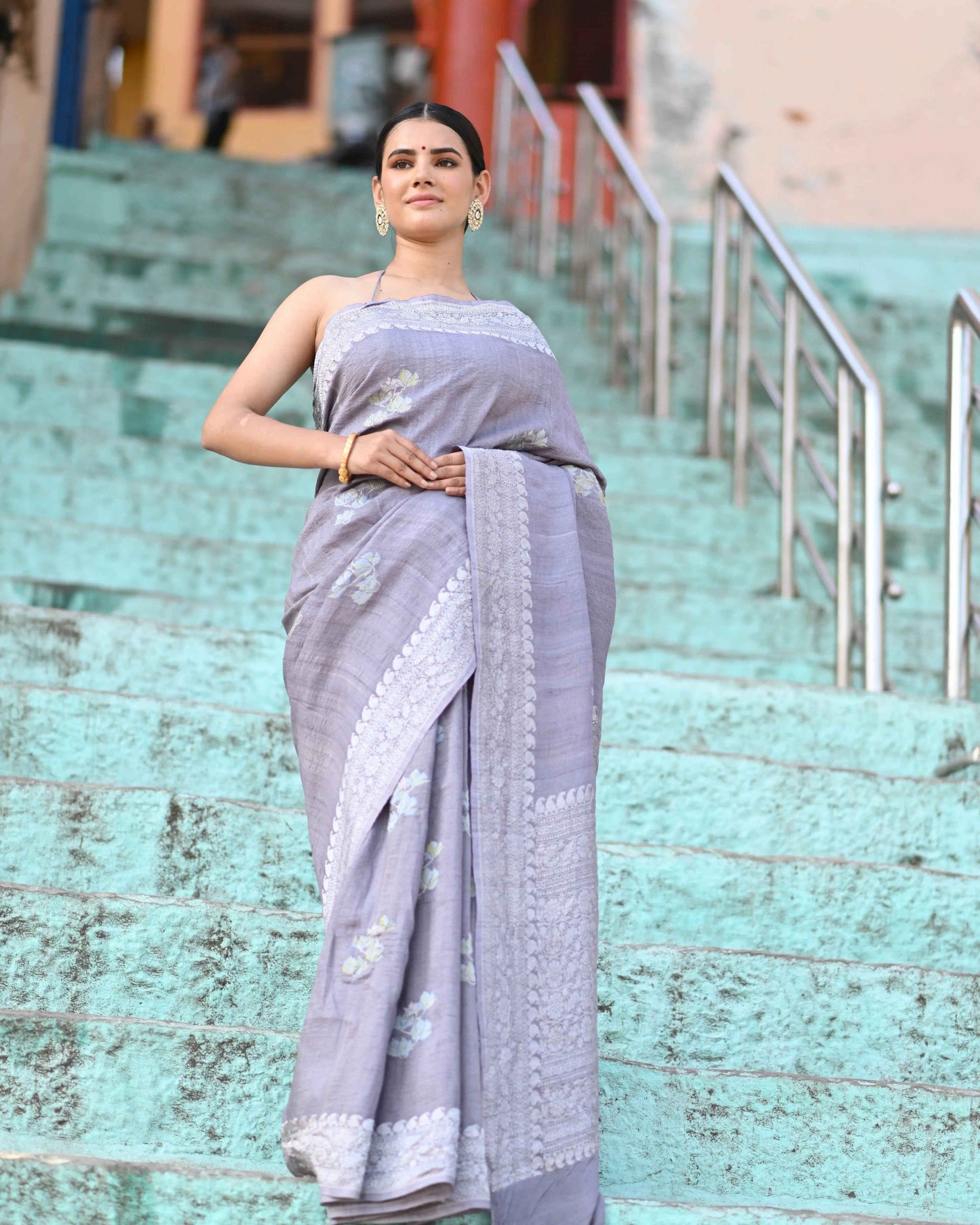 Blue-gray tussar silk saree with patterned border and draped pallu