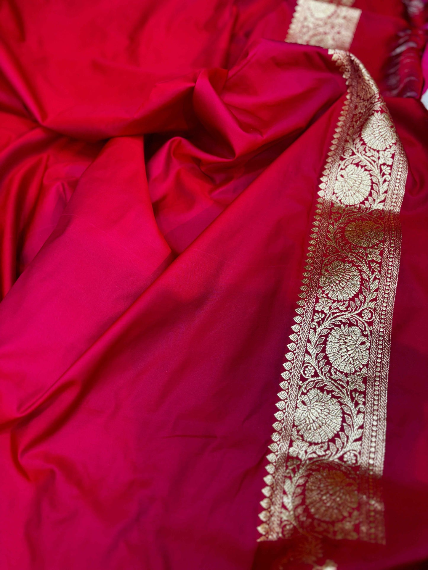 Red Banarasi saree border with intricate silver-white embroidery and gold edge on pallu