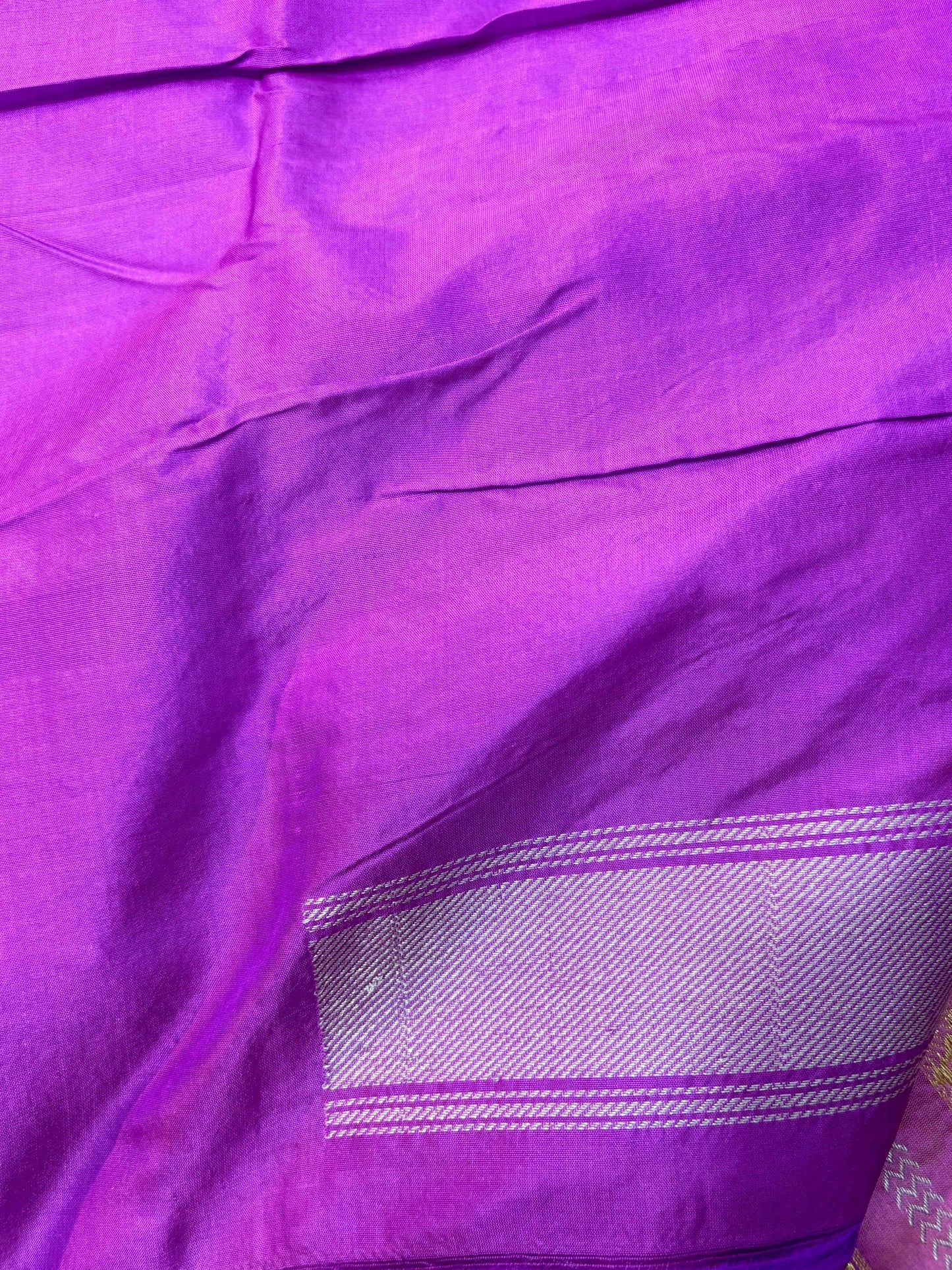 Purple Banarasi silk saree with plain drape and thin woven border along edge