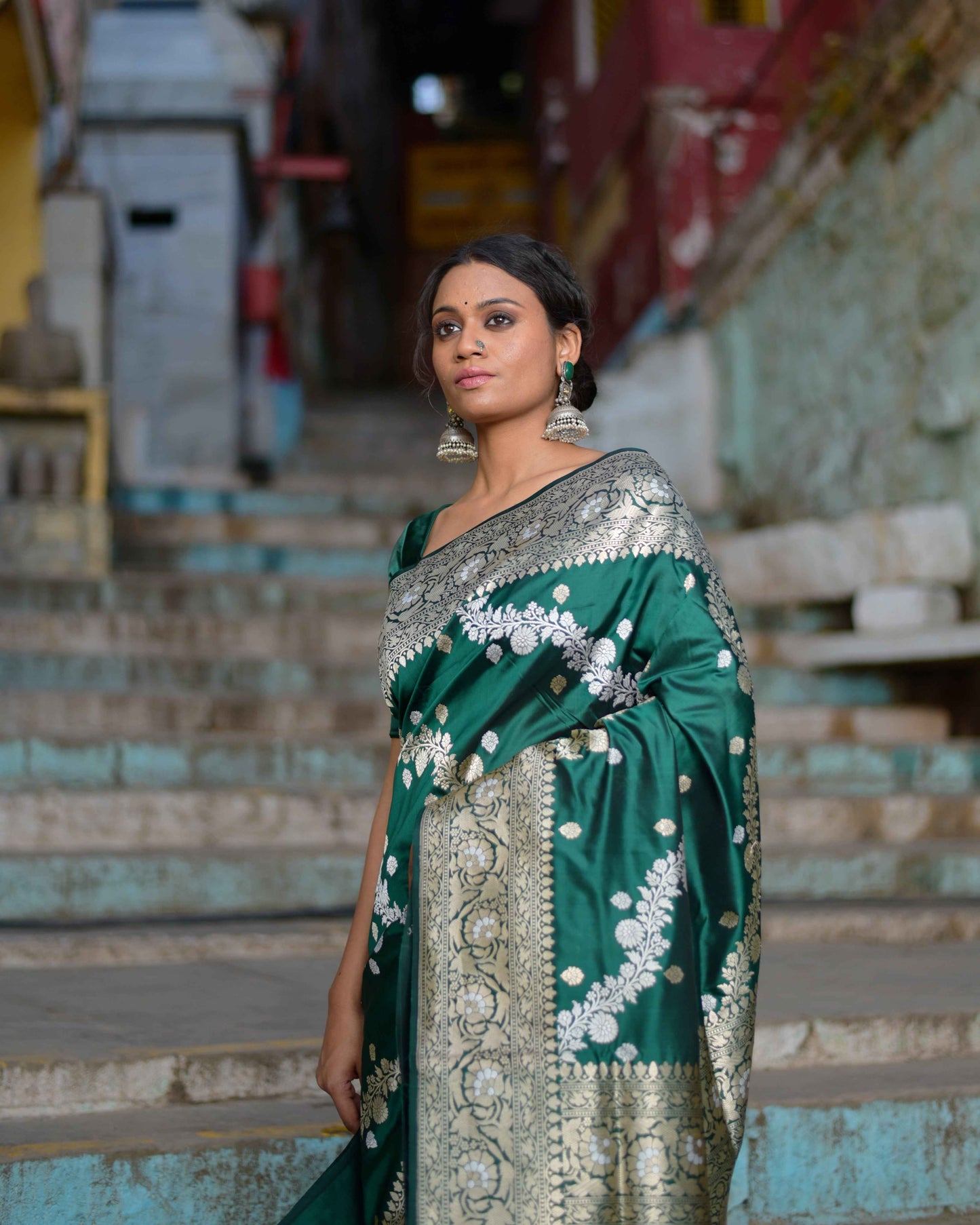Green handwoven saree with gold border and white floral motifs, draped on model