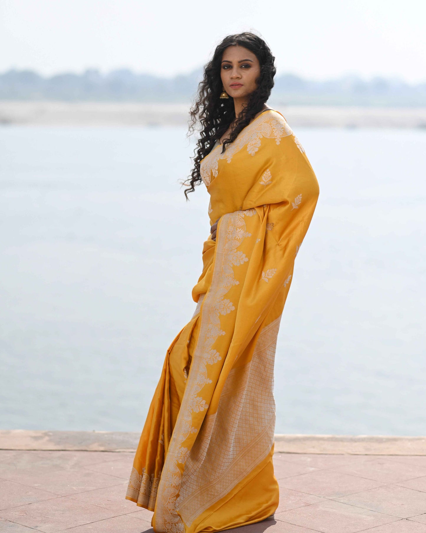 Yellow handwoven saree with light gold bootas and draped pallu