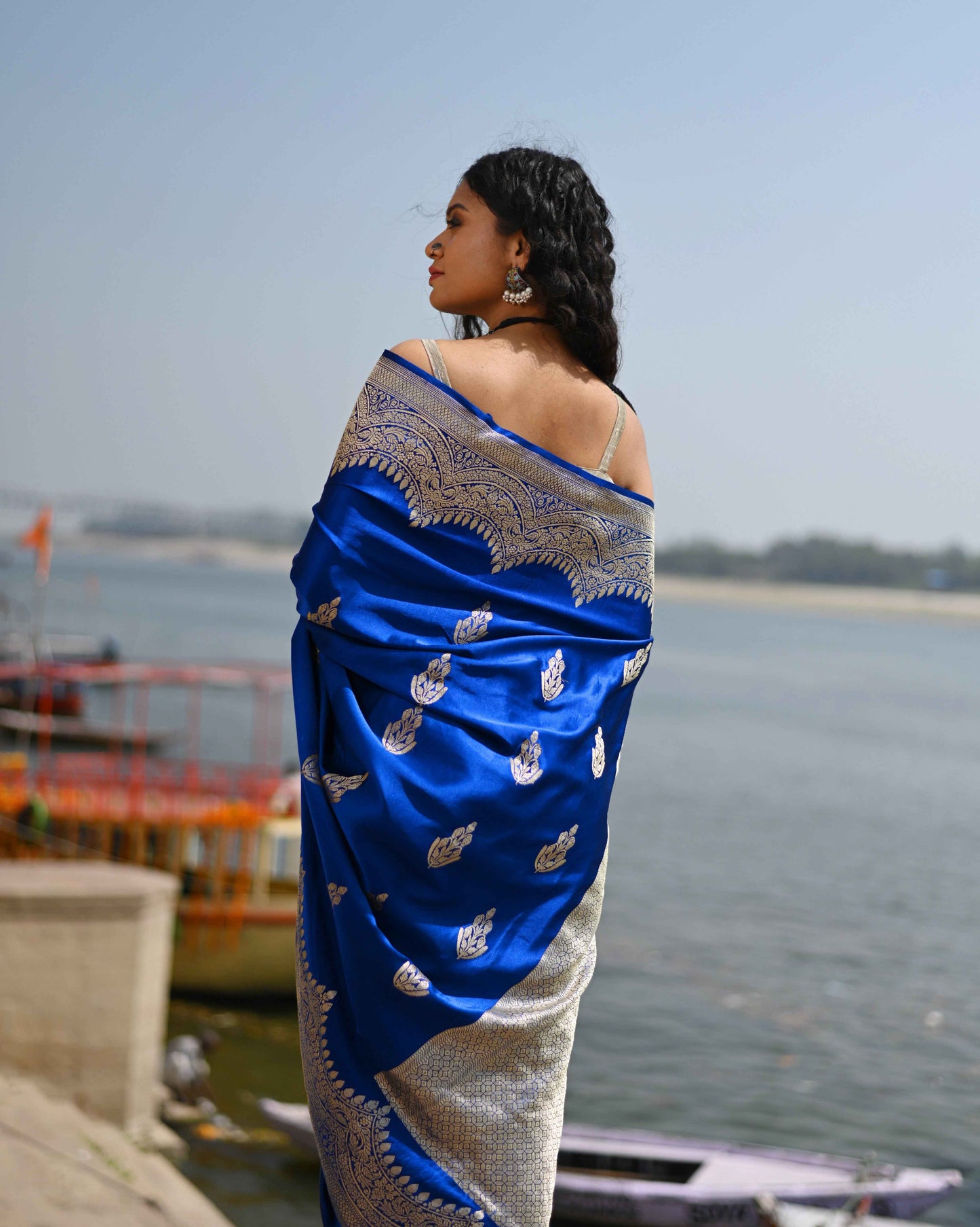Blue Banarasi-style saree with silver zari border and gold bootie motifs, draped