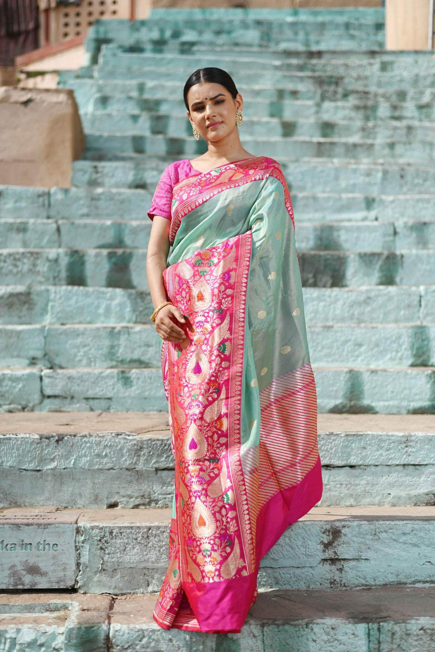 Light sky blue saree with pink floral motifs and border, draped on model