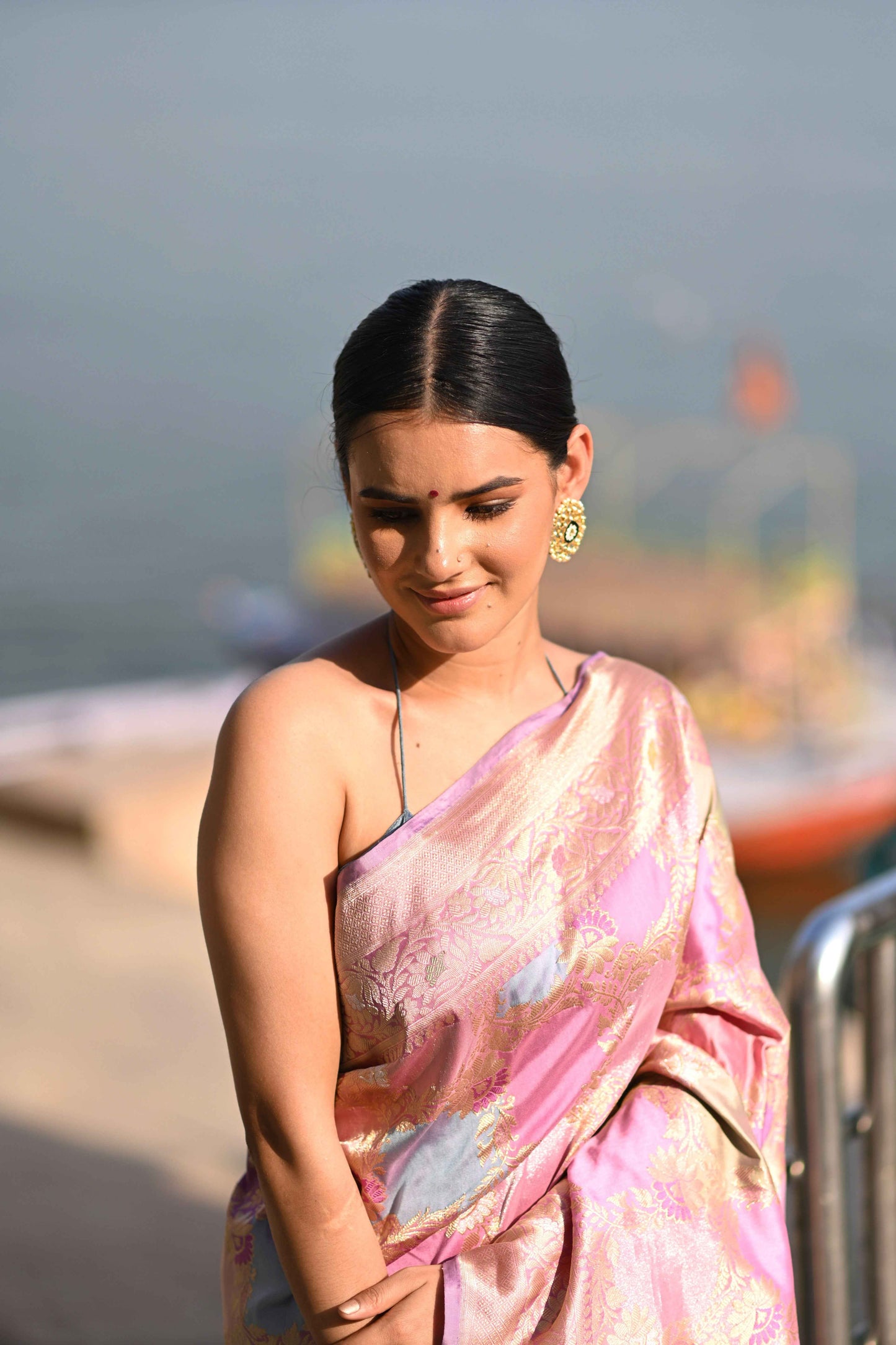 Baby pink silk saree close view with gold motifs and woven sheen