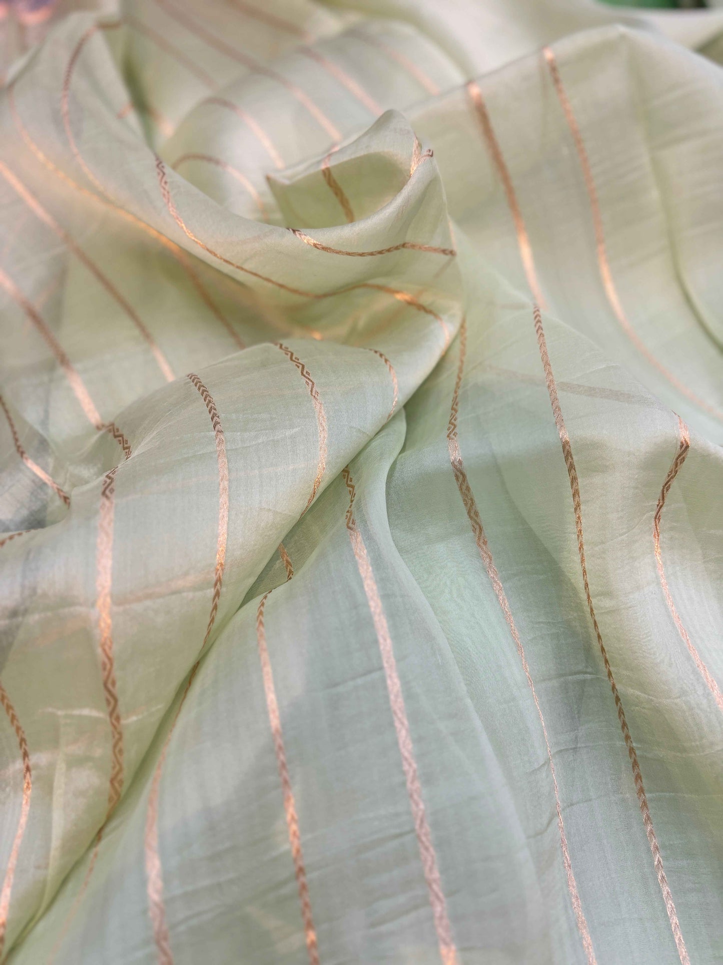 Banarasi handloom saree close-up in off-white with thin peach stripe lines and fine texture