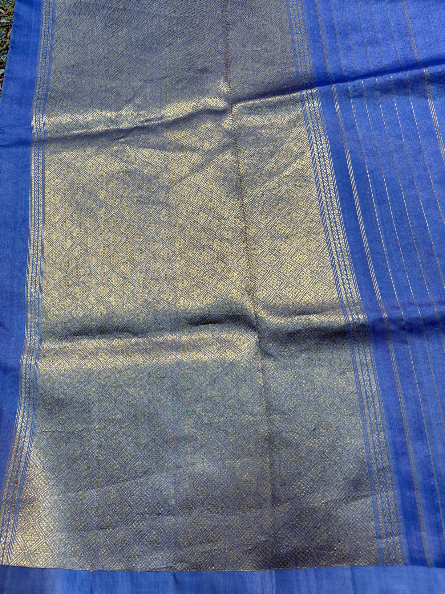 Light blue saree pallu with textured gold sheen and narrow woven border stripes