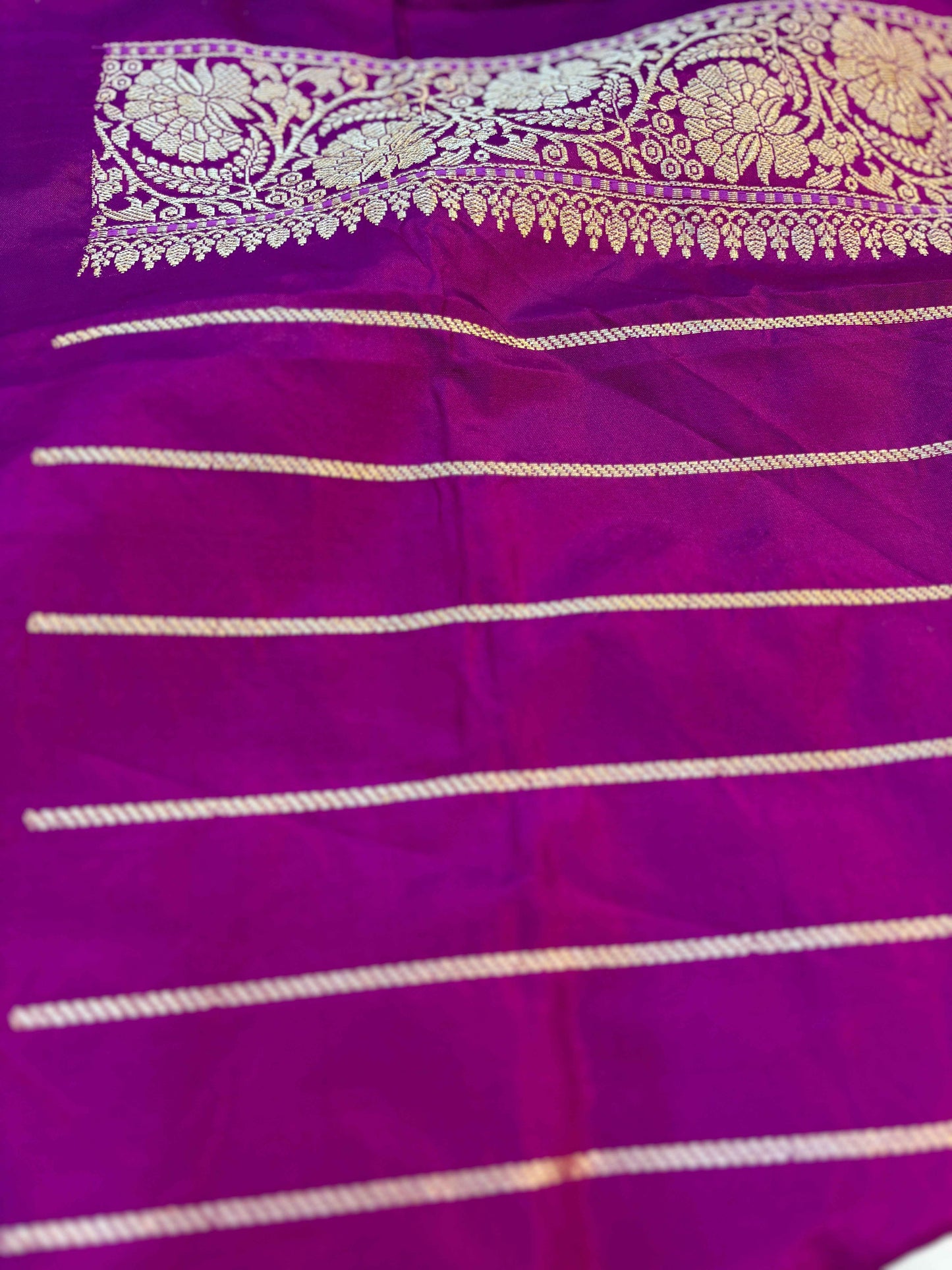 Purple saree border with gold patterned band and multiple gold stripe lines