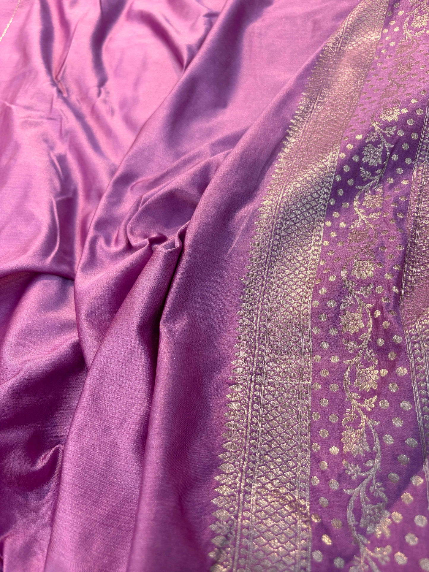 Lavender silk Banarasi saree with ornate gold border and textured zari panel