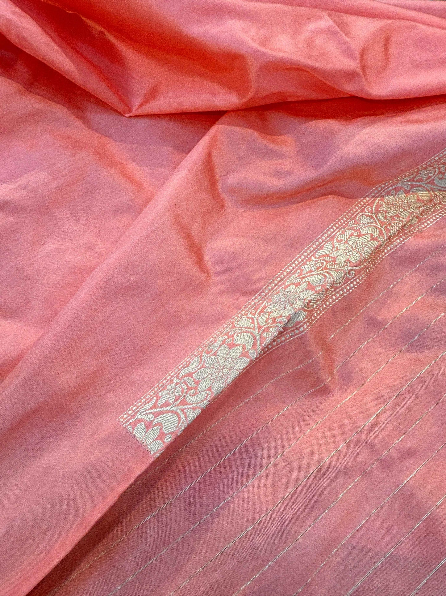 Pink silk saree with gold zari stripe and small woven motifs along the edge