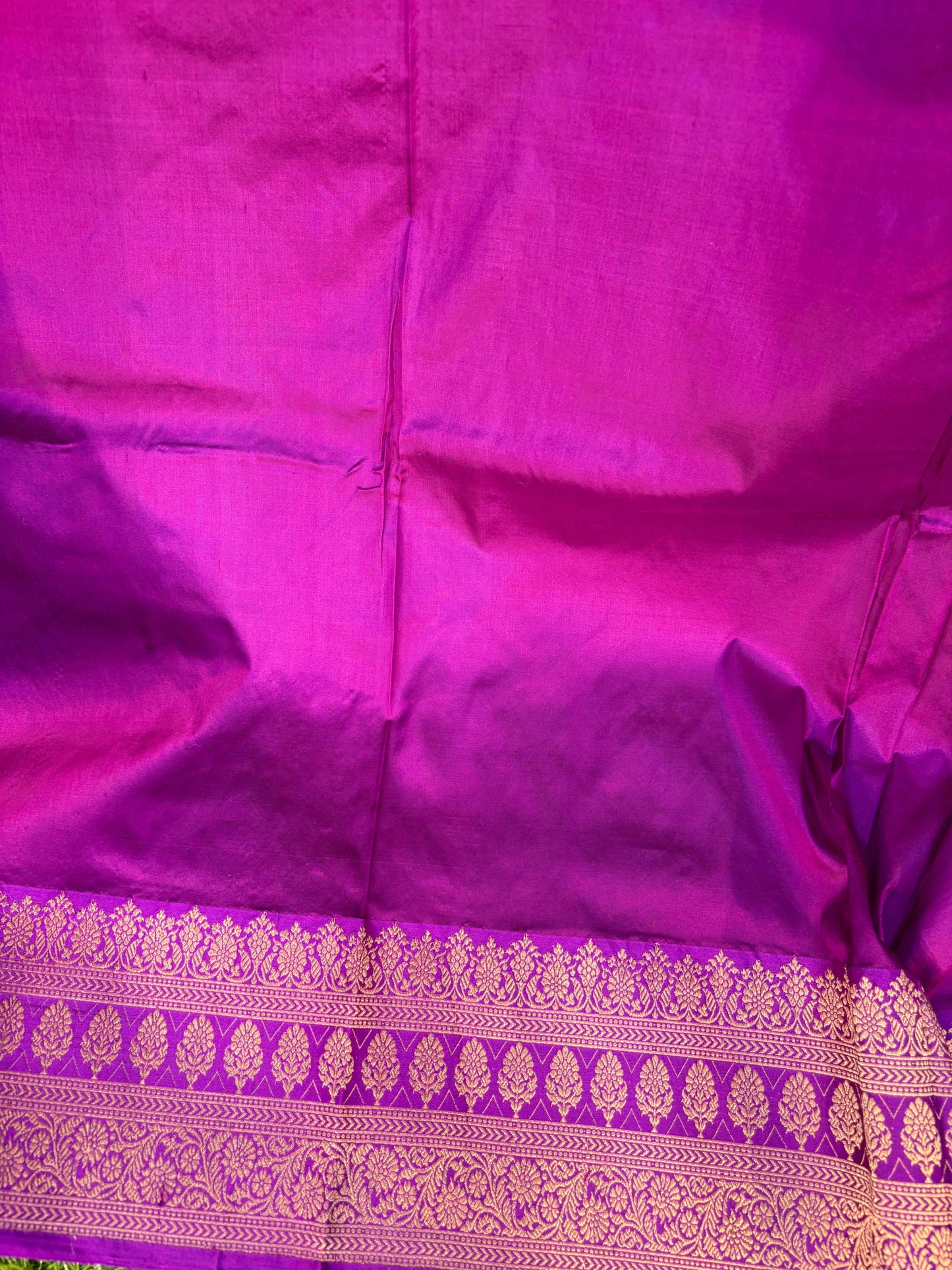 Purple saree with decorative purple-gold border, folded fabric view