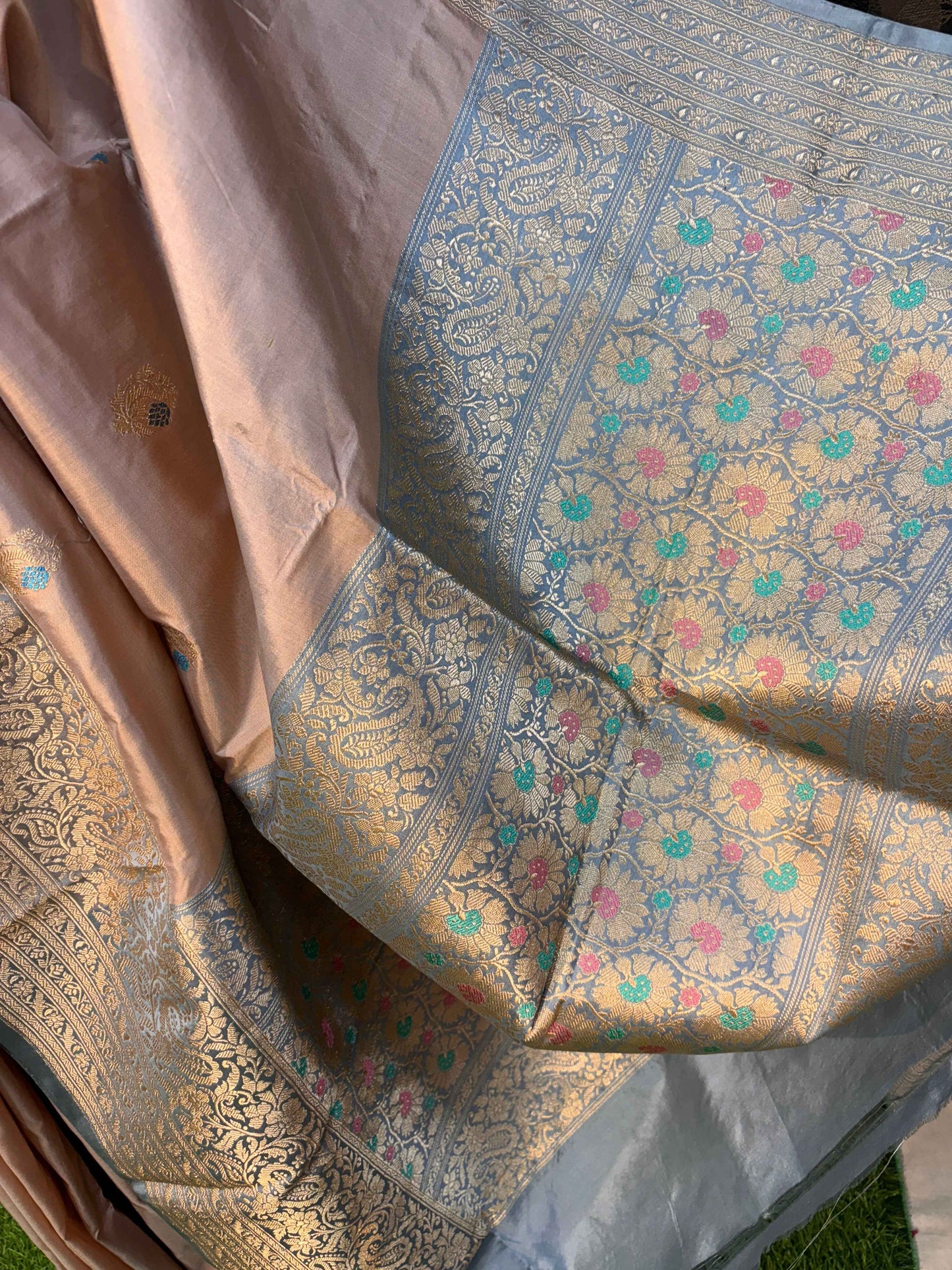 Banarasi handloom saree fabric close-up with blue floral motifs and gold zari work