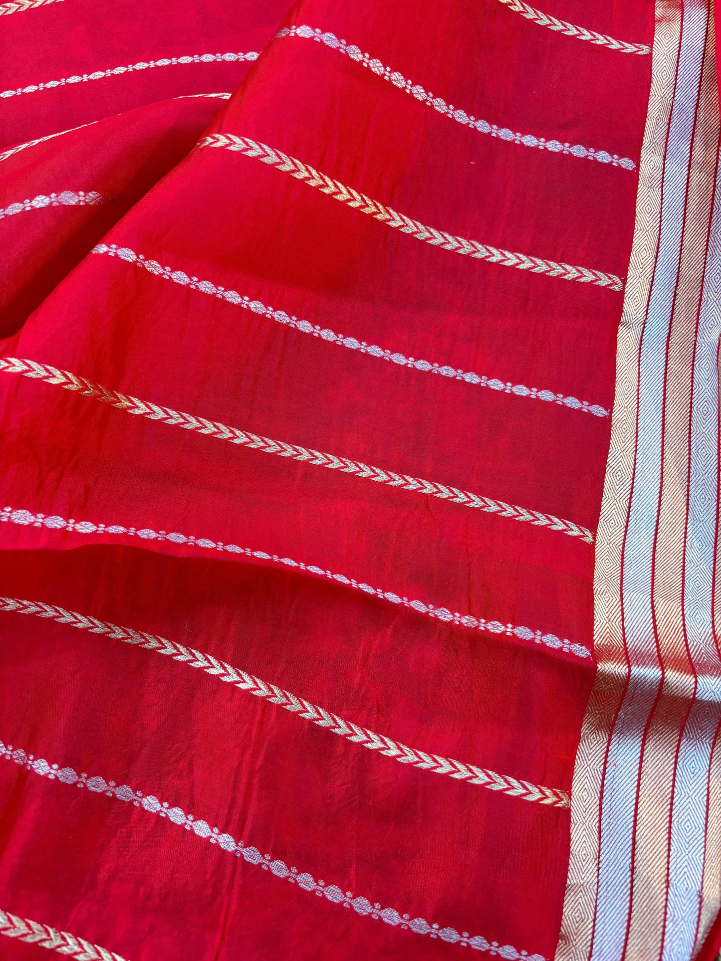 Red saree close-up with cream chevron stripes and woven border