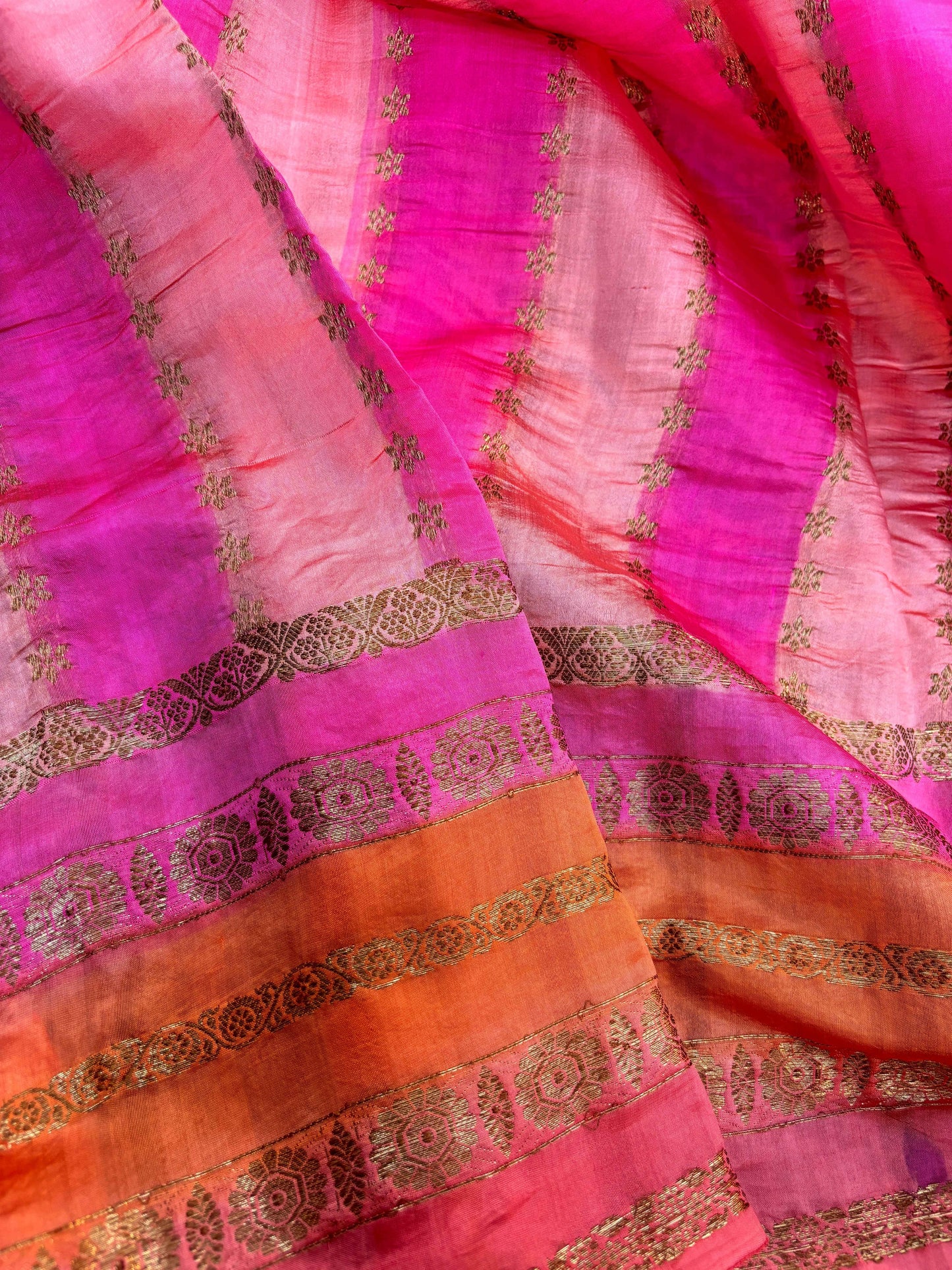 Pink peach saree pallu with magenta panels and gold woven motifs, close-up