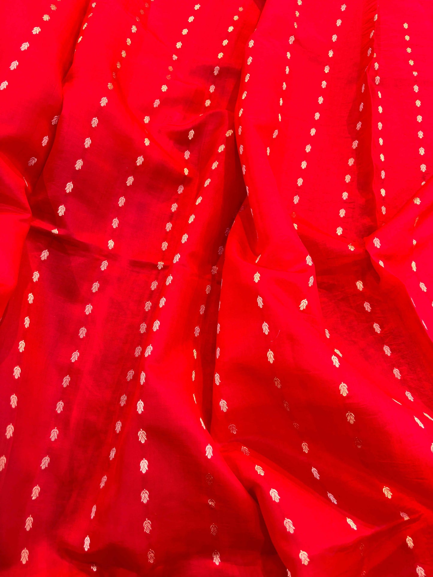 Red Banarasi saree fabric with small gold motifs and dotted zari highlights