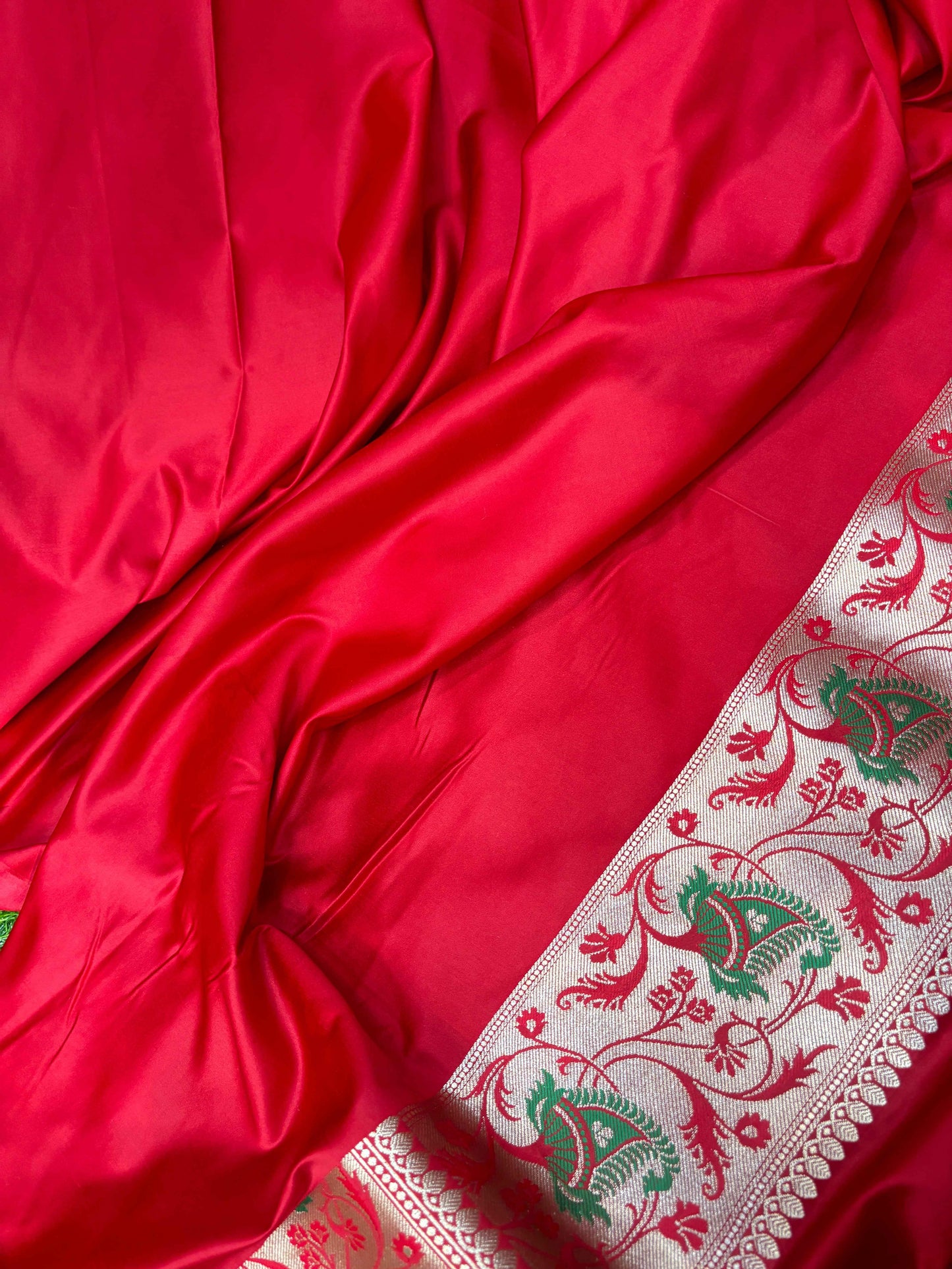 Maroon silk saree with white and green floral border and woven detailing