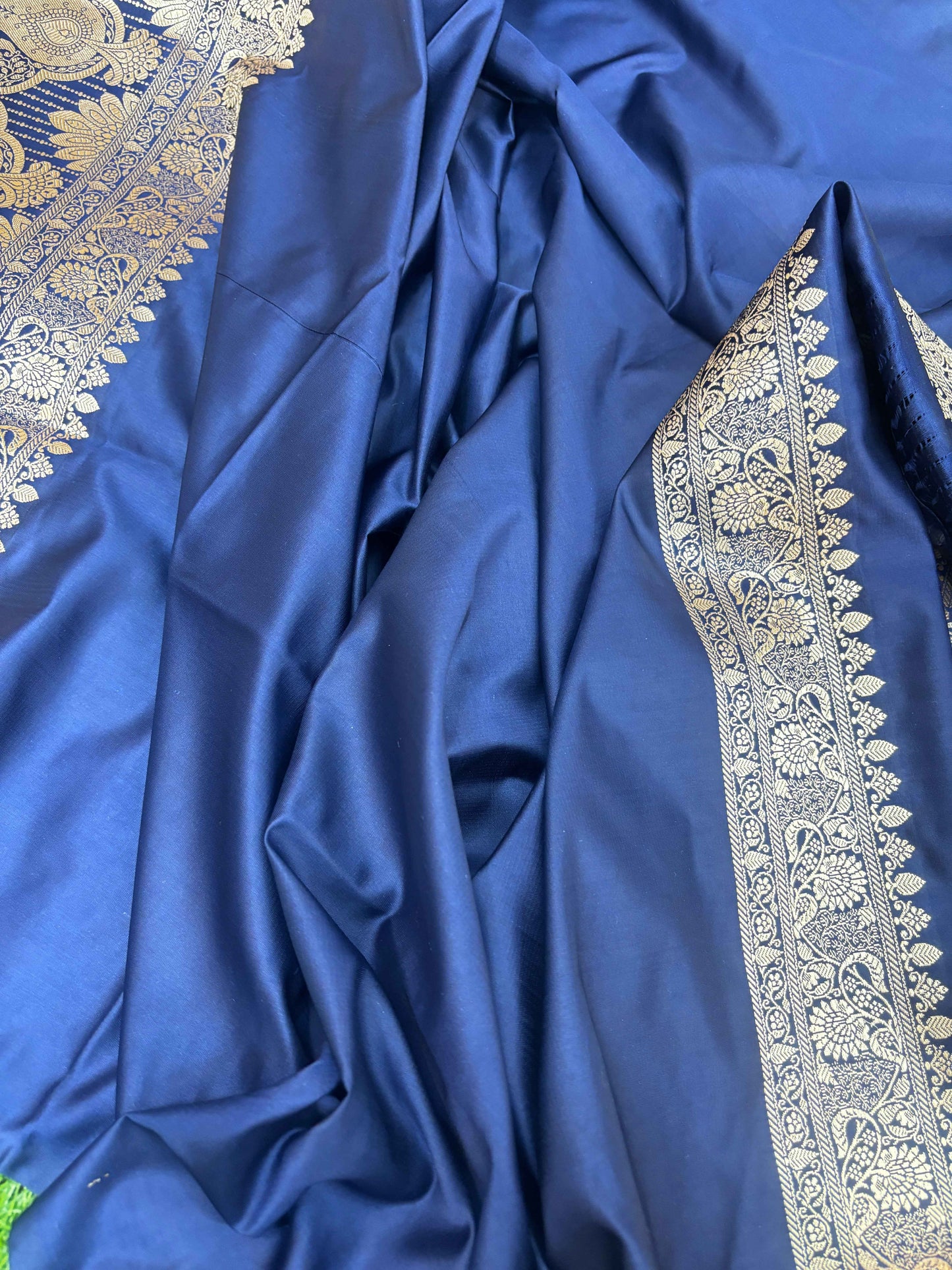 Navy blue silk saree fabric close-up with silver-gold border detailing
