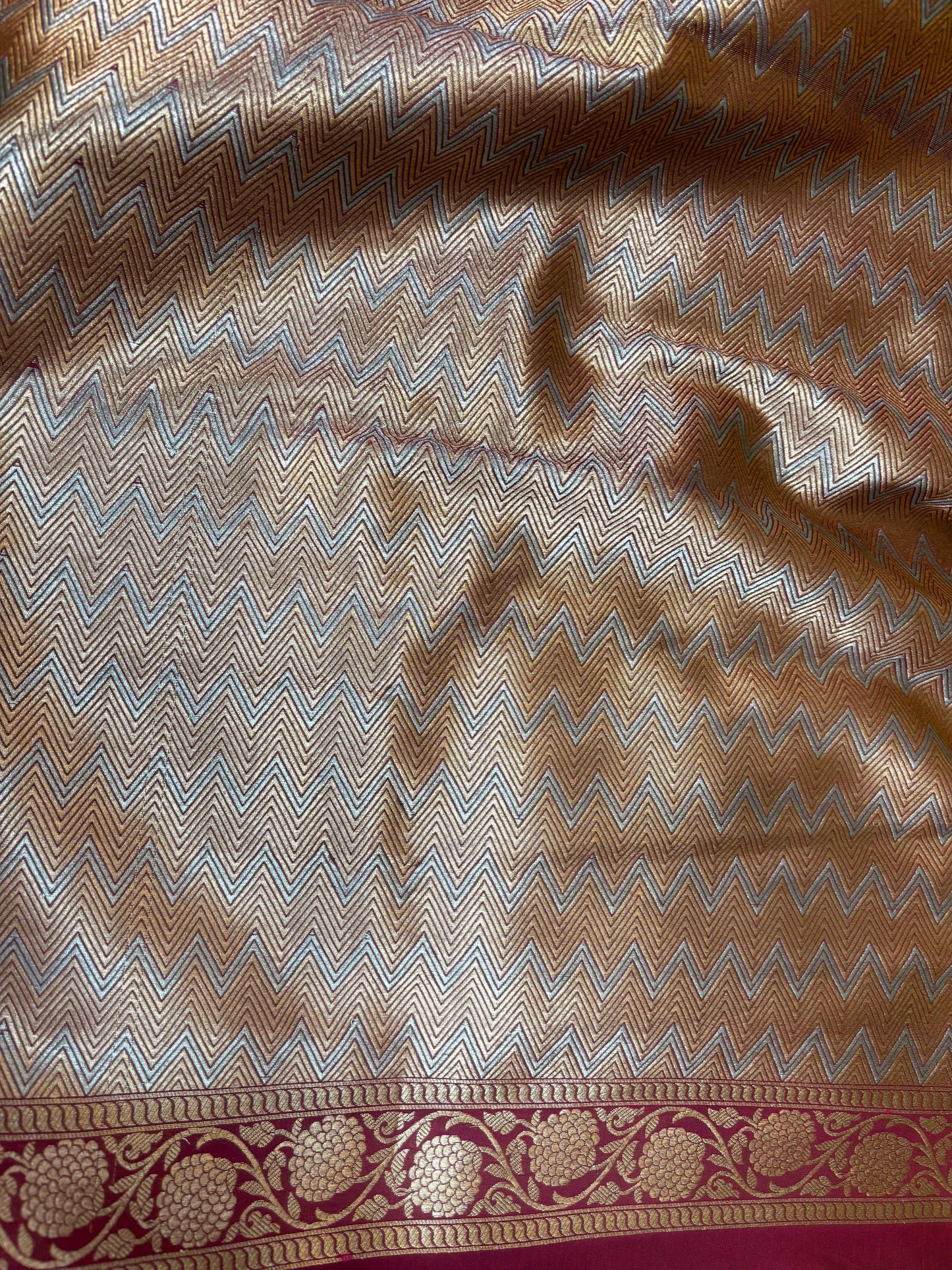 Silk Banarasi saree fabric close-up with zigzag weave and gold border trim