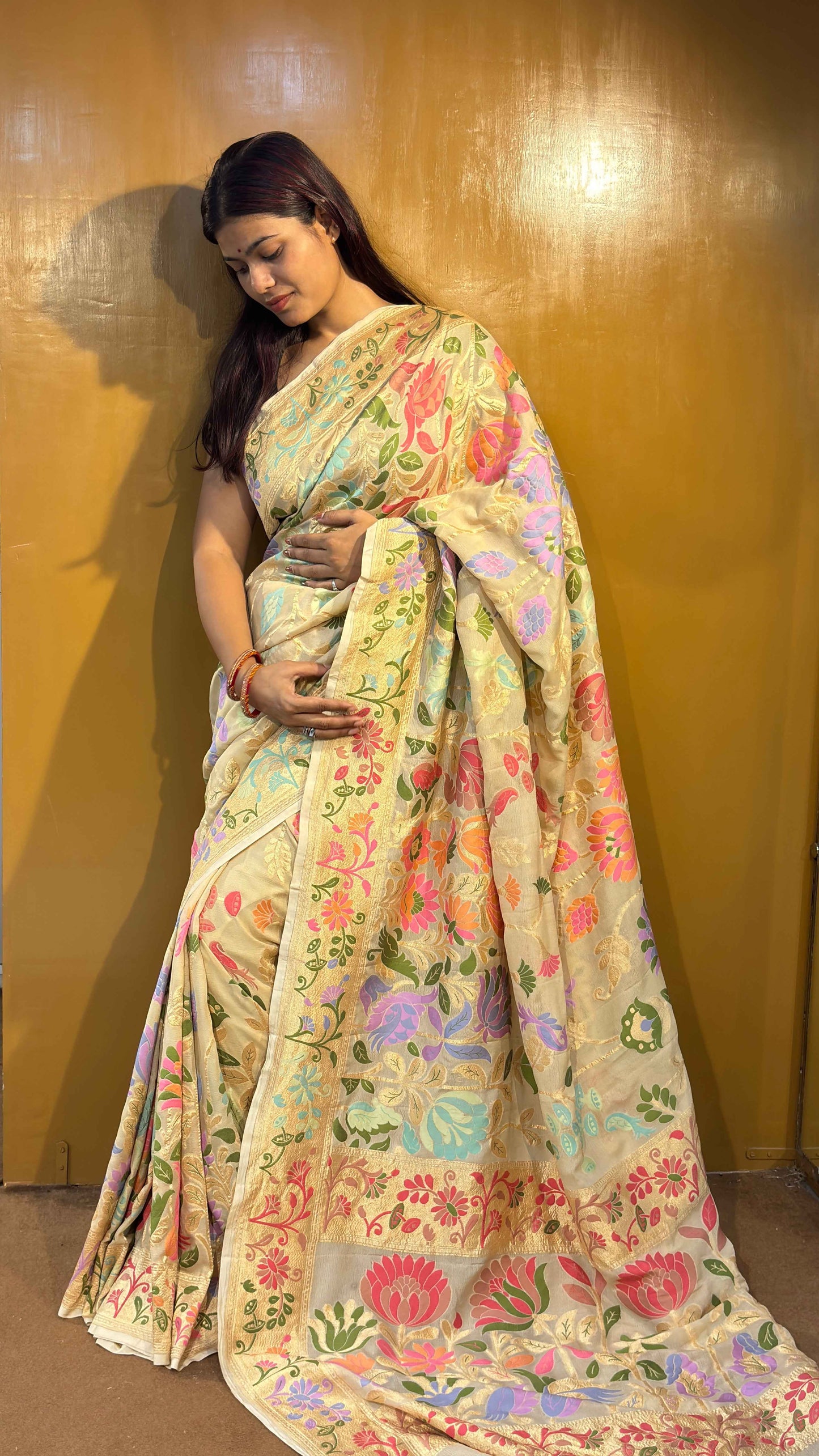 Pastel floral sari with decorative motifs and wide border, full drape visible